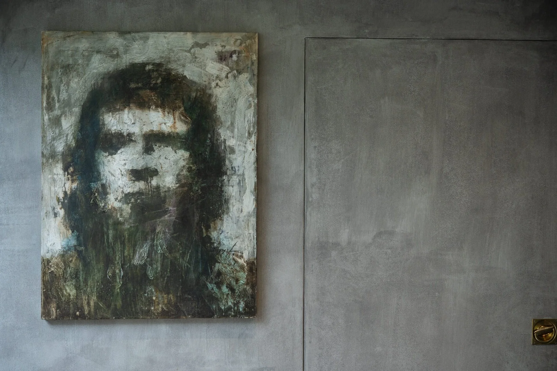 Abstract portrait of a woman on a textured canvas hung on a gray wall.