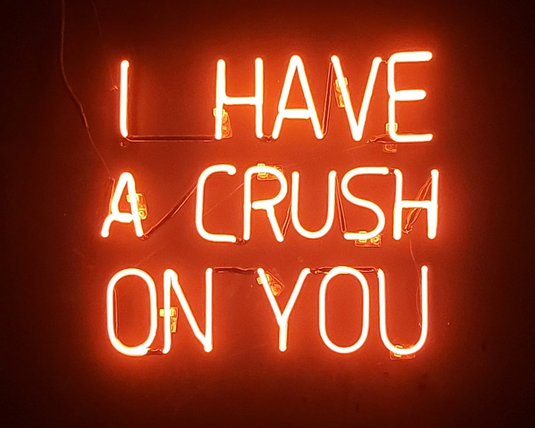 Neon sign with the words "I HAVE A CRUSH ON YOU" in bright red and orange colors.