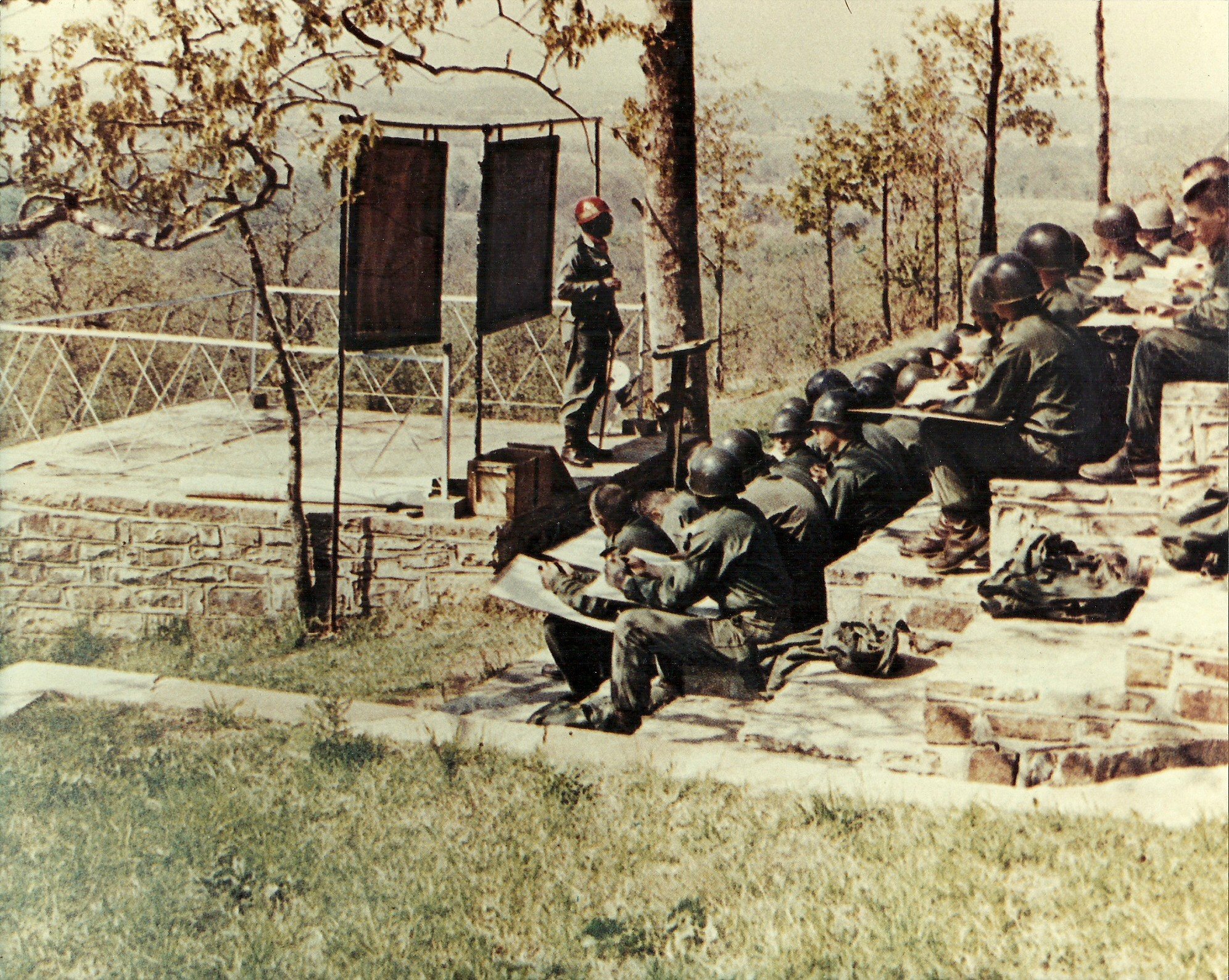 a group of U.S. Army soldiers attending an outdoor training or educational session