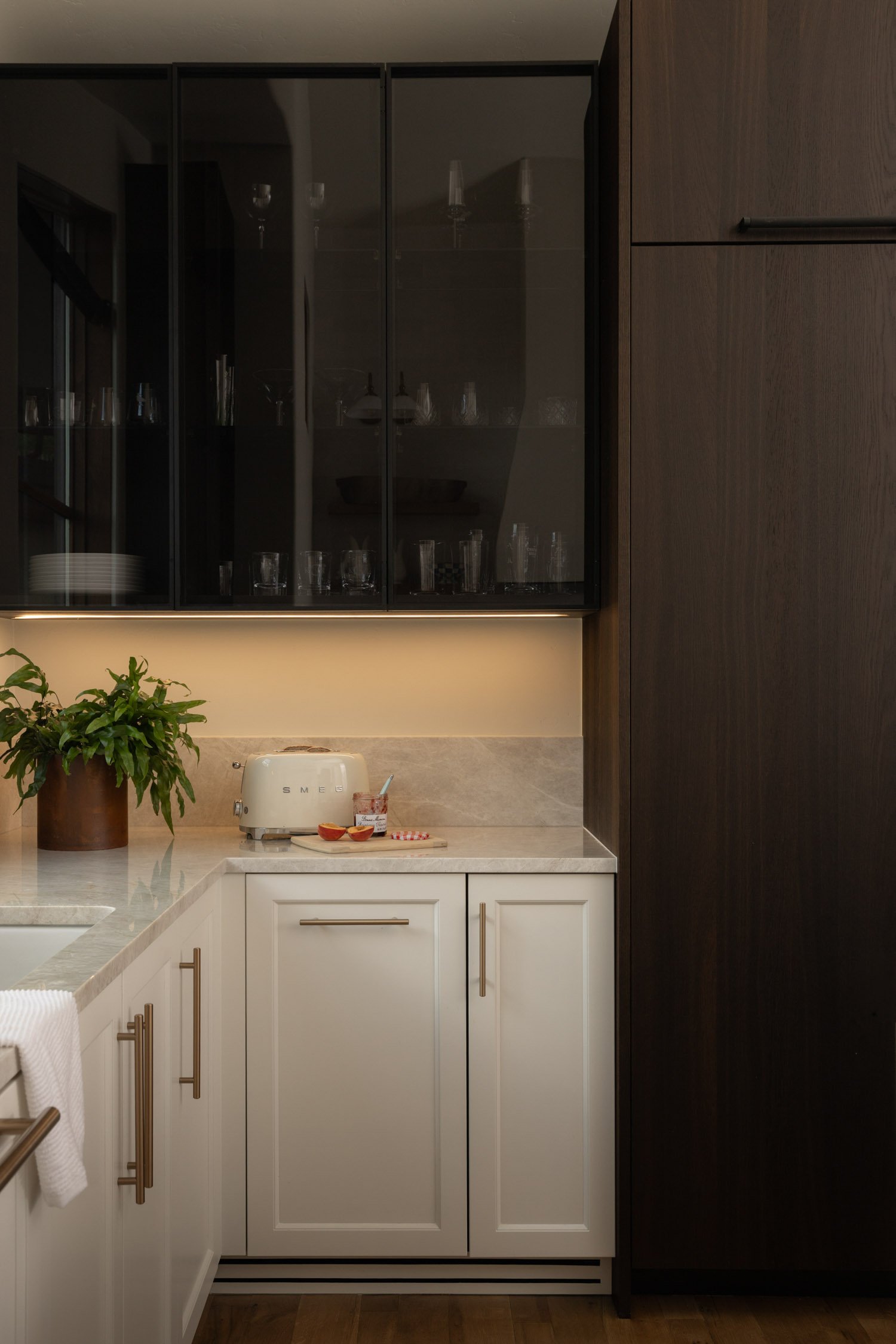 Warm kitchen with contrasting cabinets, granite counters and white tile backsplash by Vail interior designer Krista Weisman