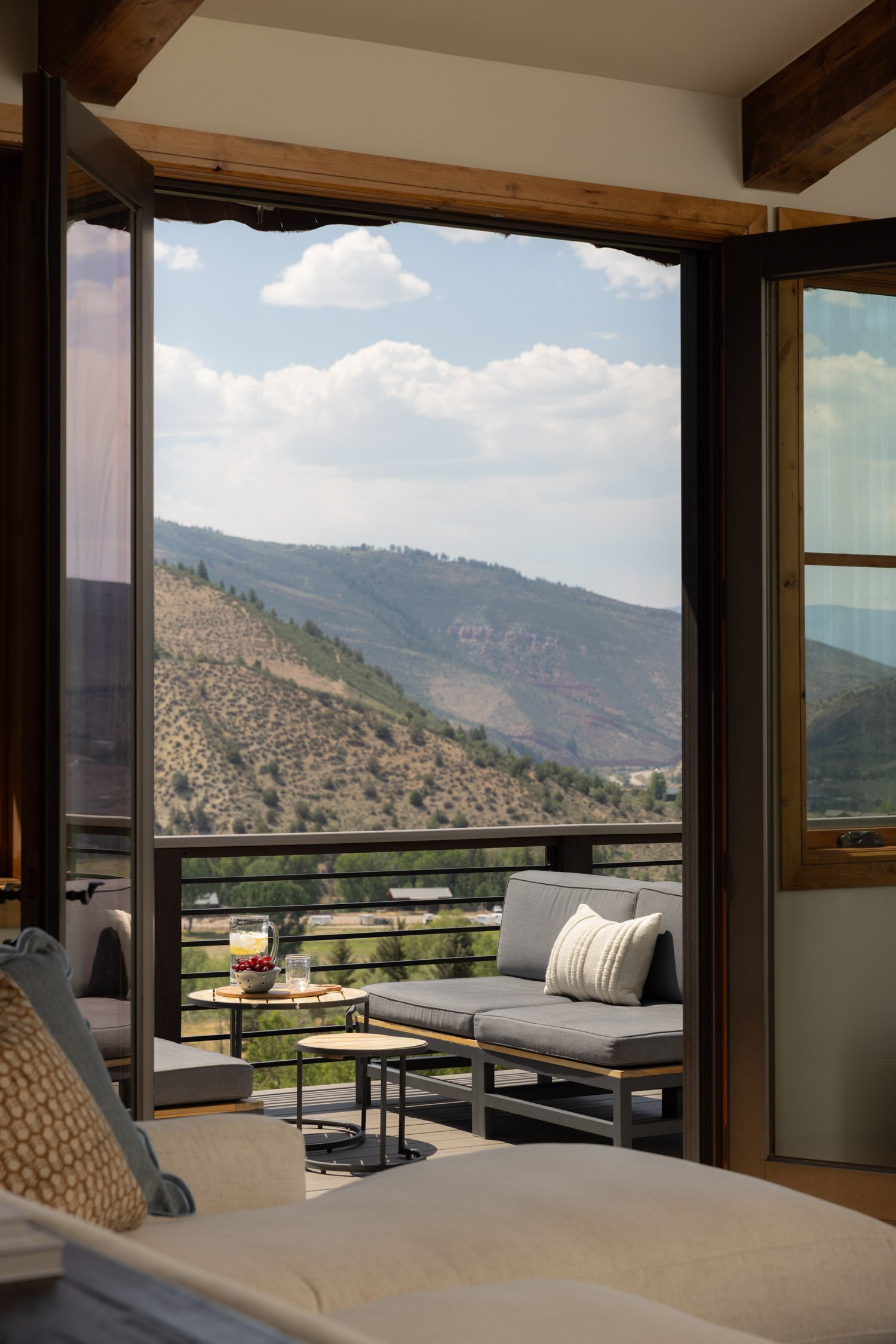 Deck with sofa and mountain view in Vail home design, by Krista Weisman at Intentional Design Company.