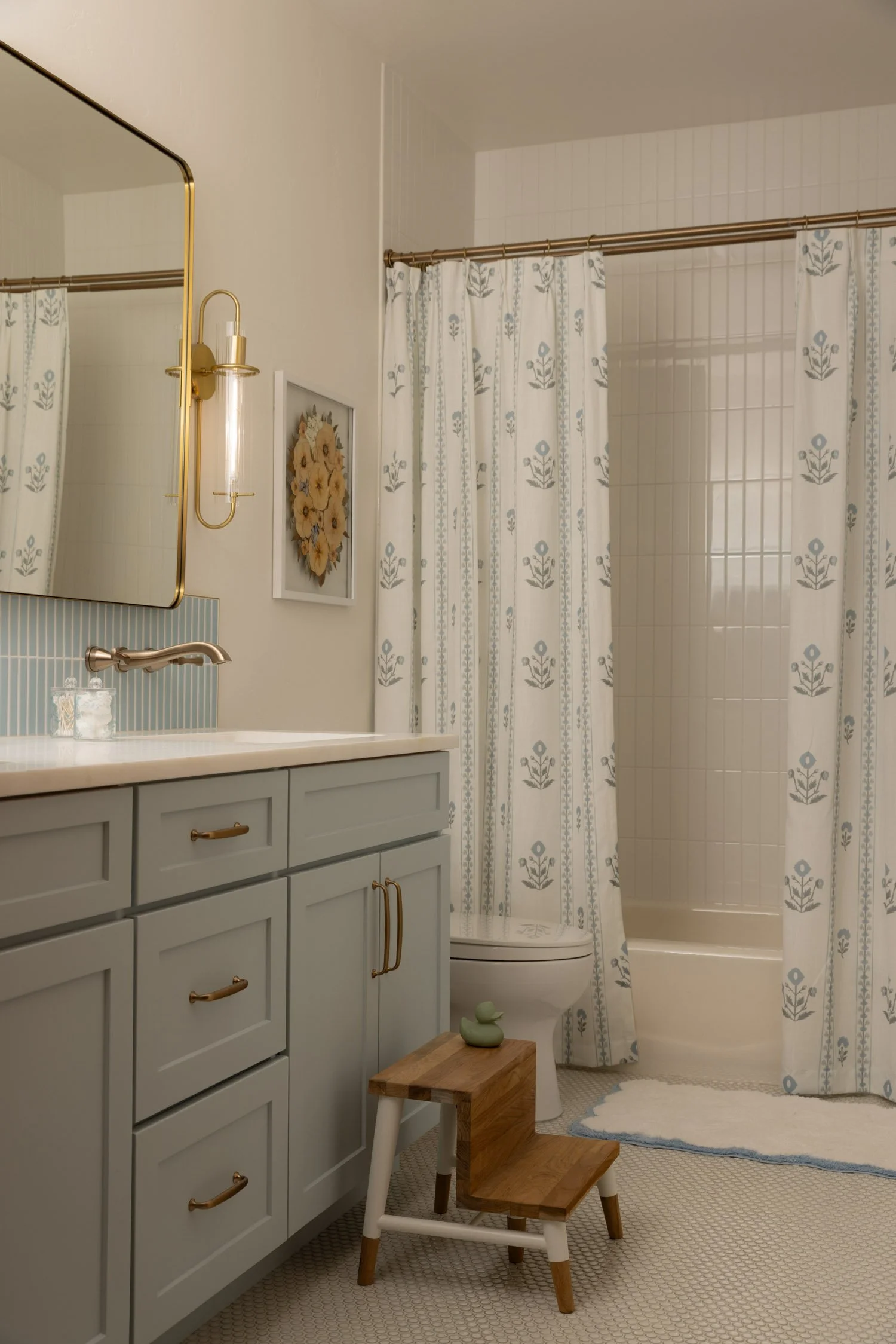 Bathroom with blue cabinets and vertical tile in Vail home designed by Krista Weisman