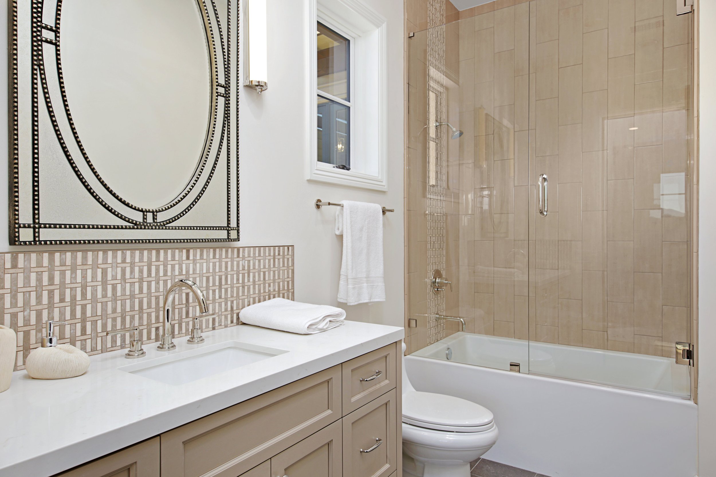 Bathroom with vanity, mirror, bathtub, and toilet.