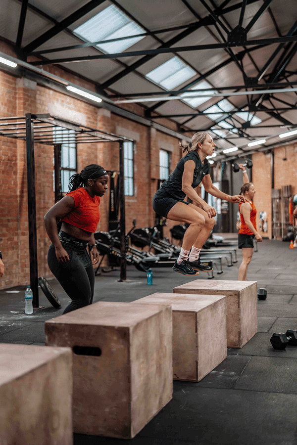 Group of people exercising doing box jumps