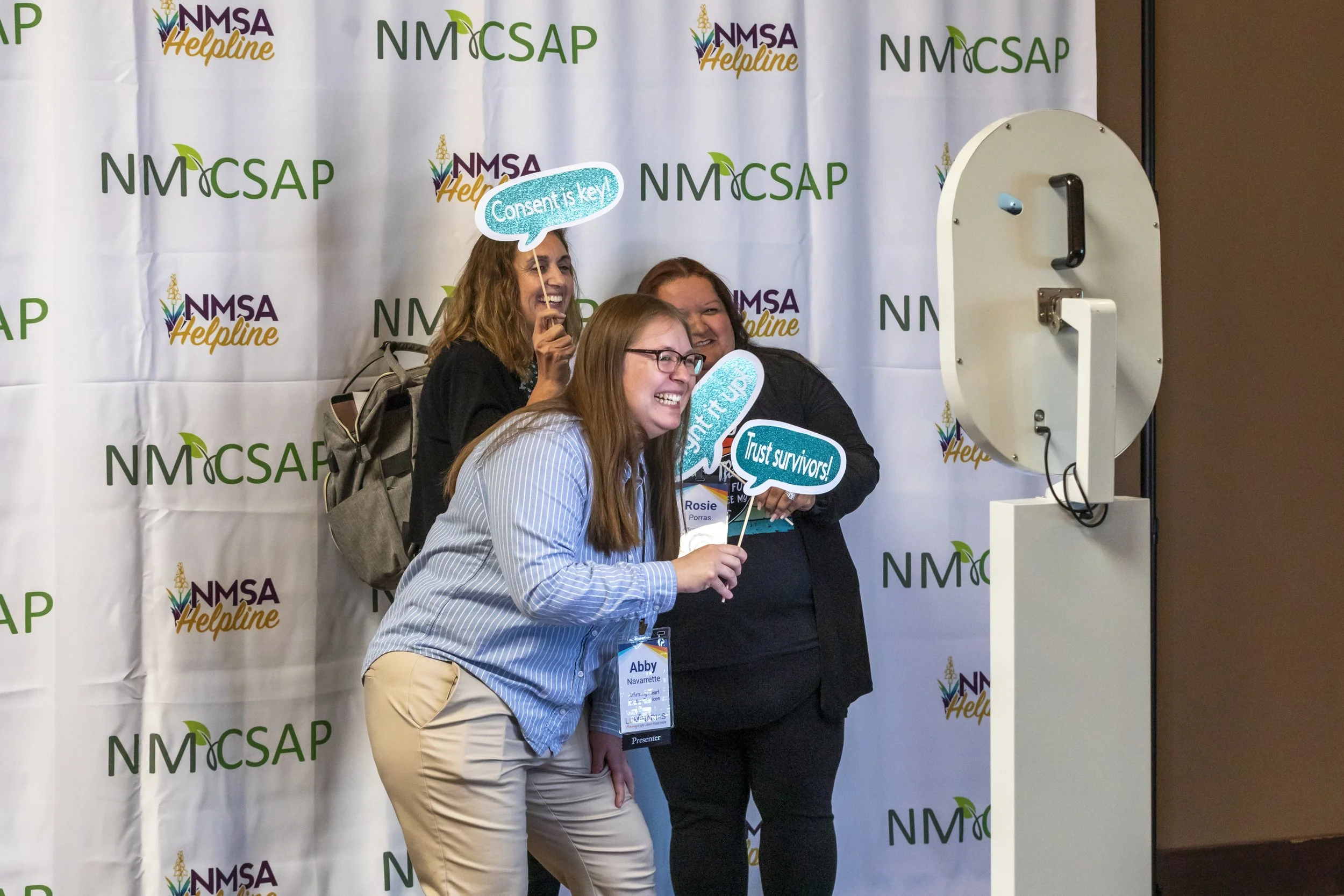 Three people posing at a photo booth