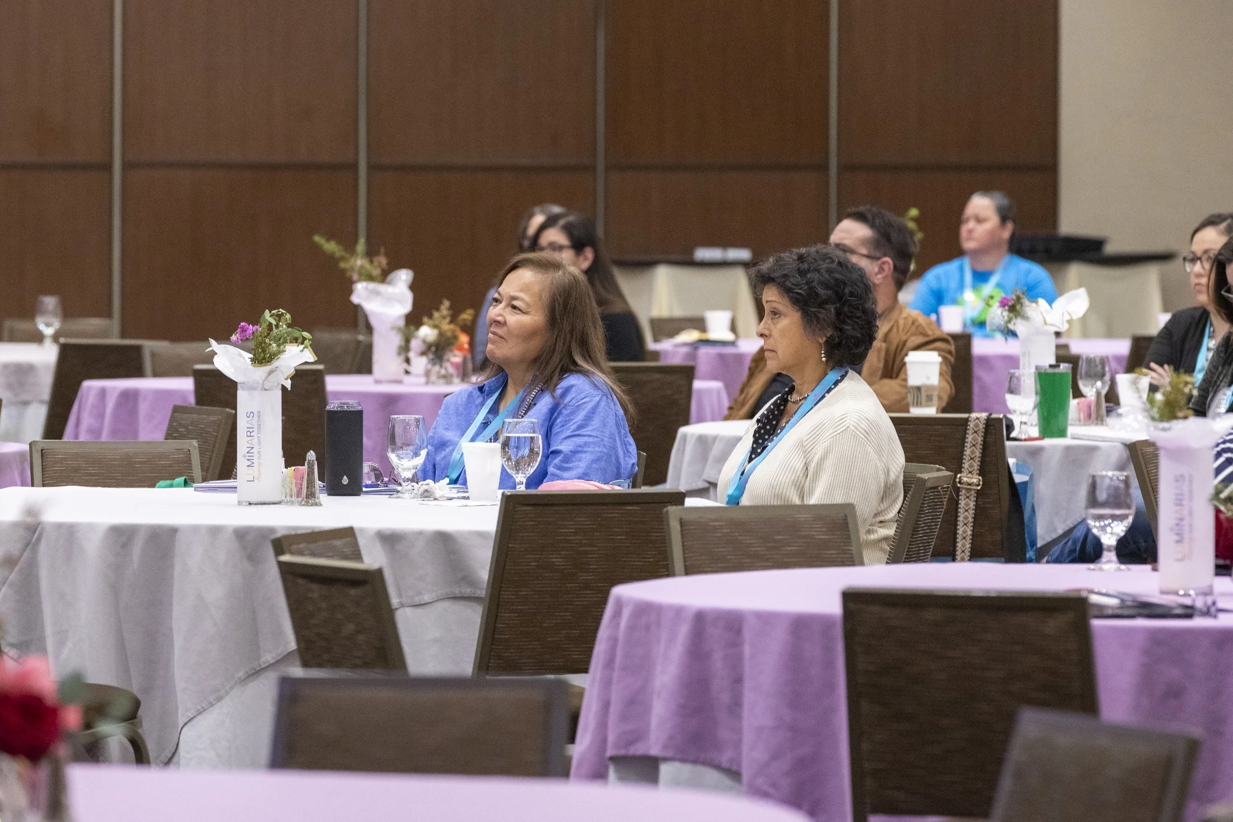 Two women watching from a table
