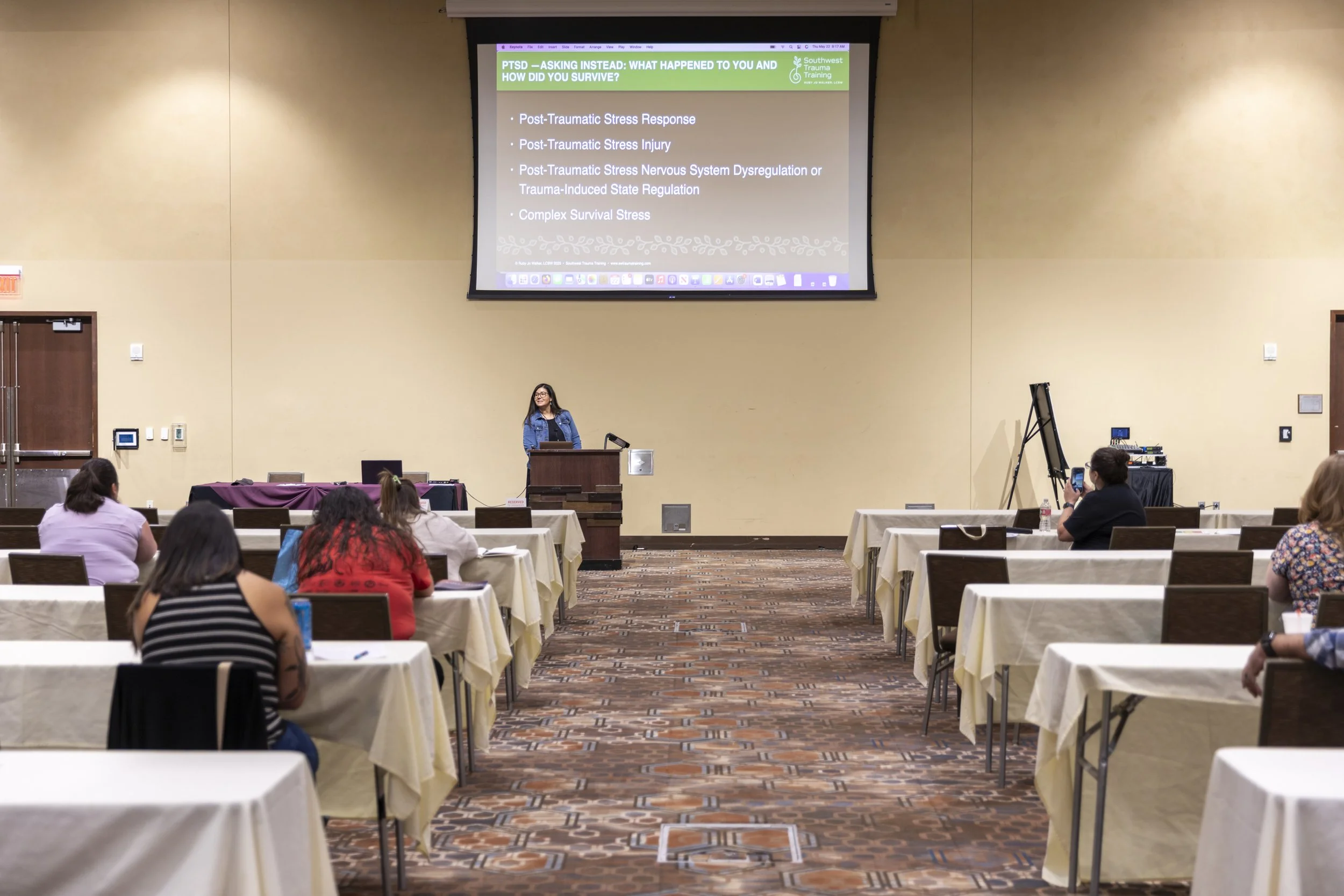 A woman presenting to a conference room