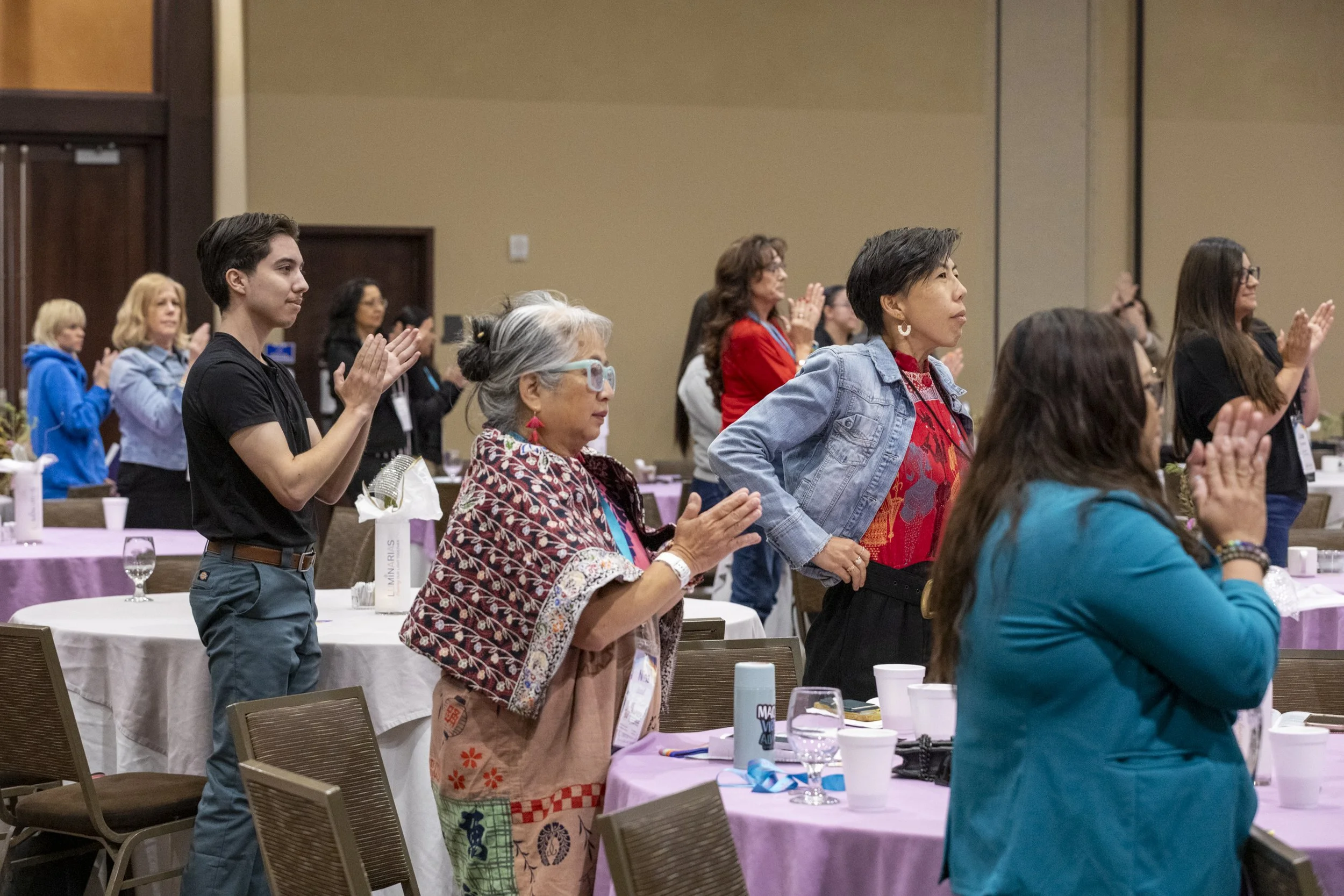 A crowd of people standing and clapping