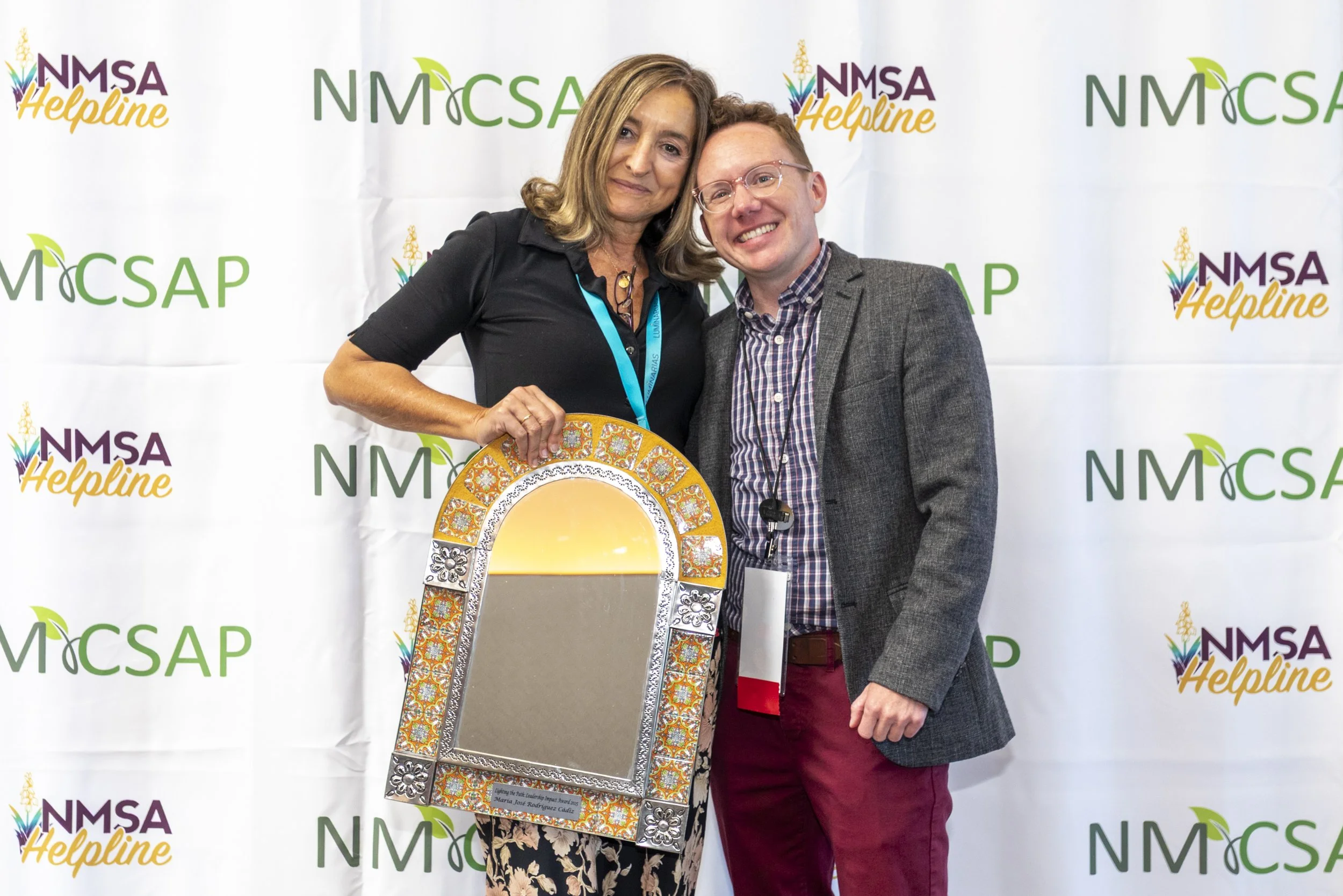 A man and woman posing with an award