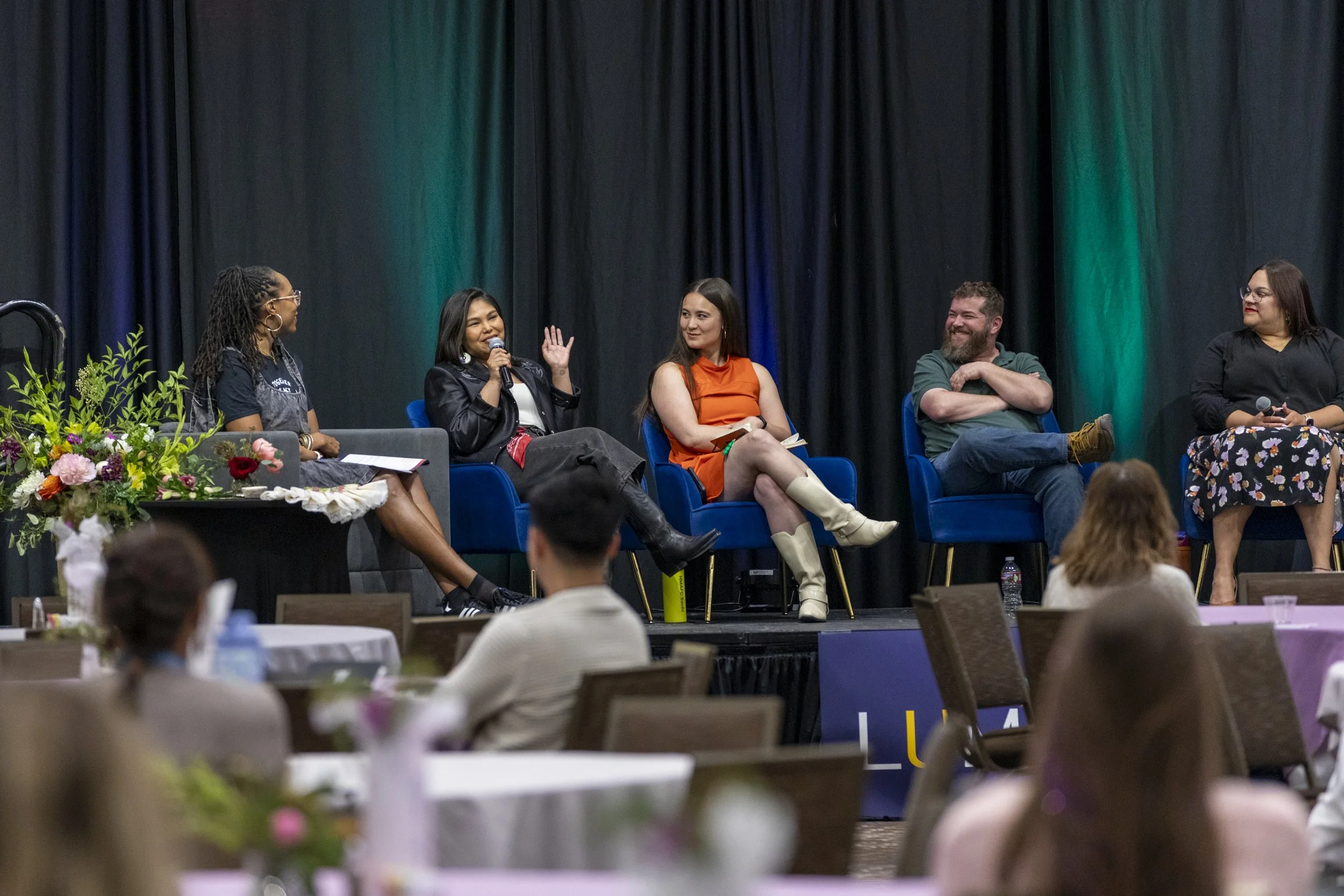 A far back picture woman on a panel speaking