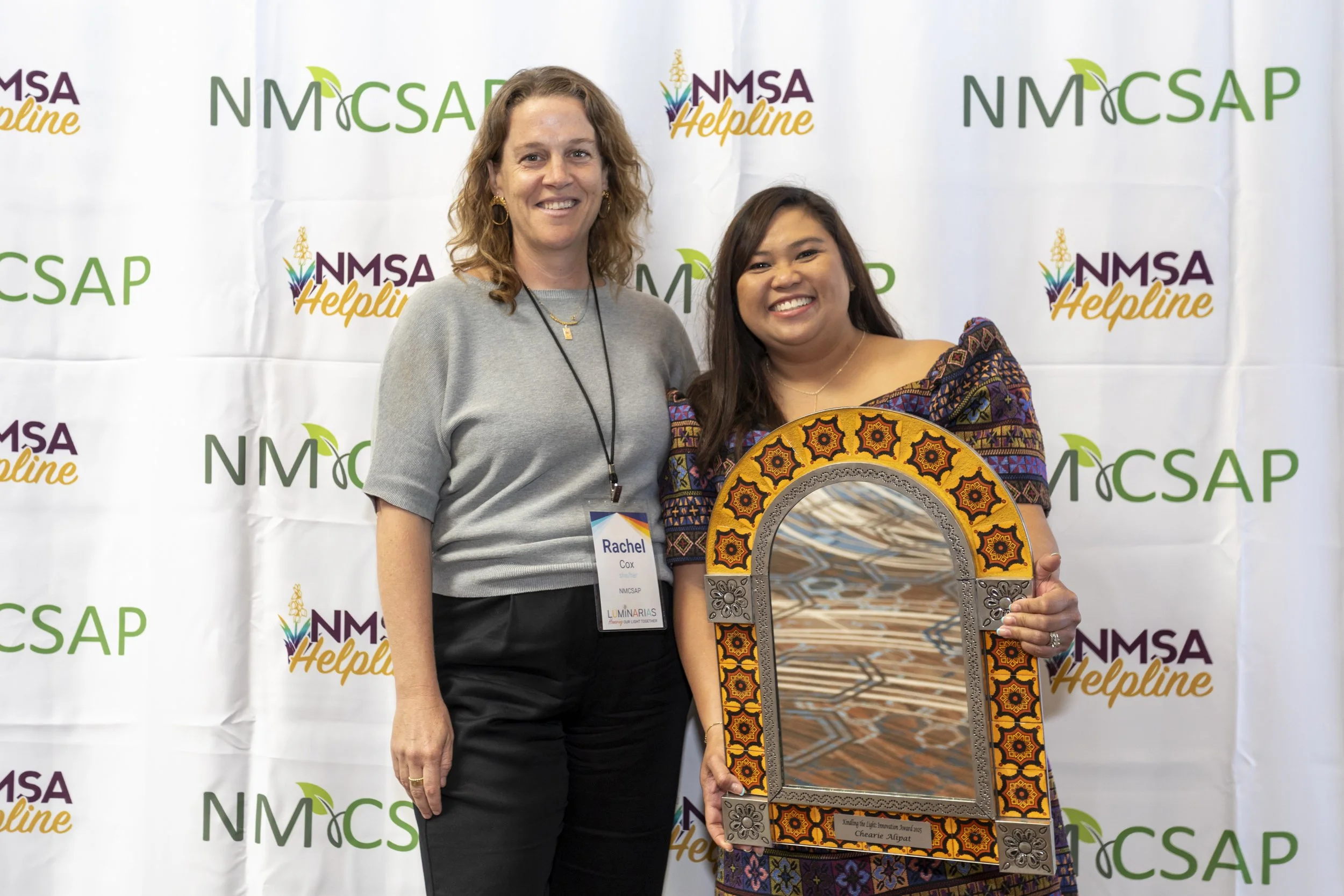 Two women posing with an award