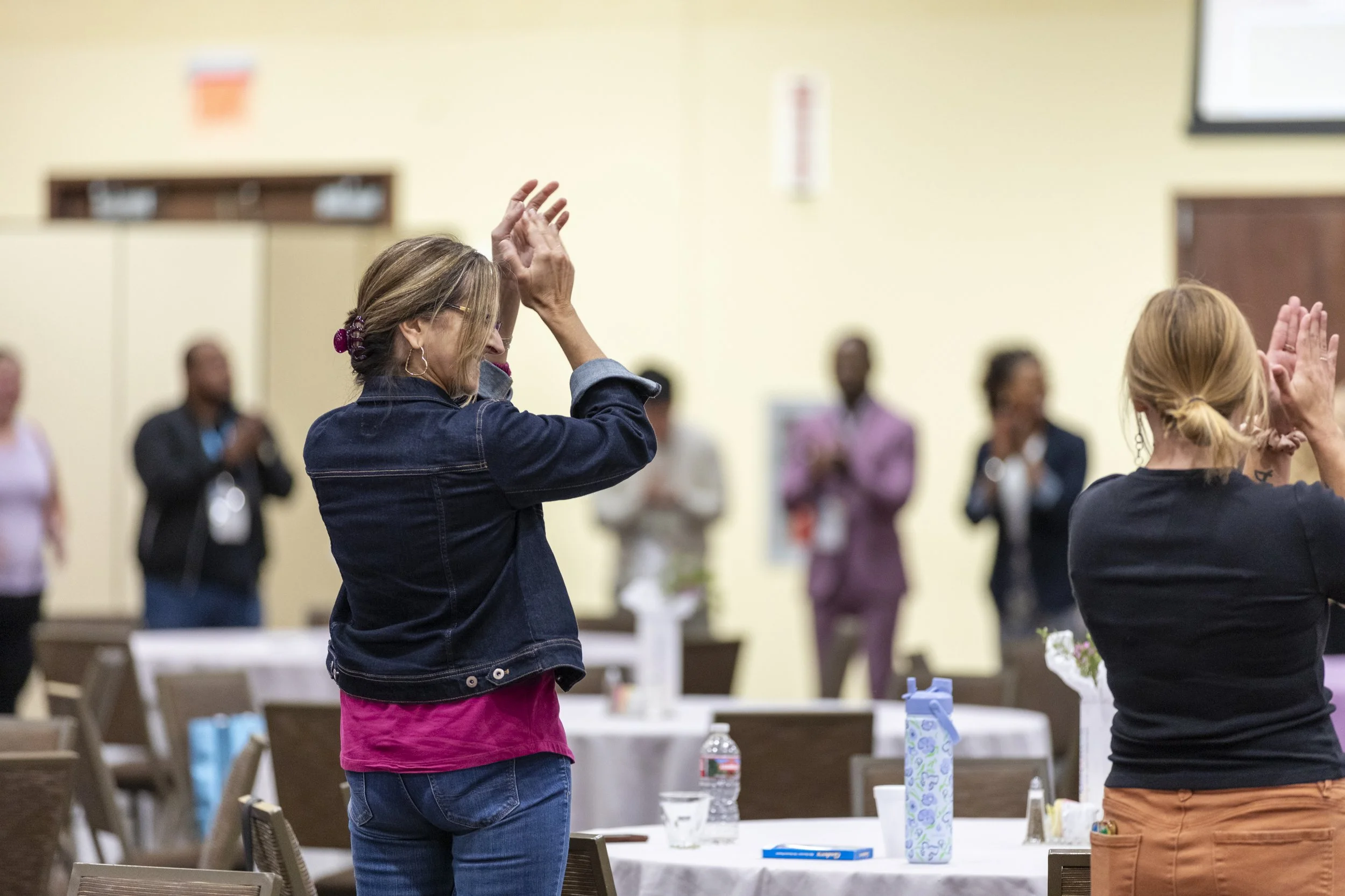 People in a circle standing and clapping
