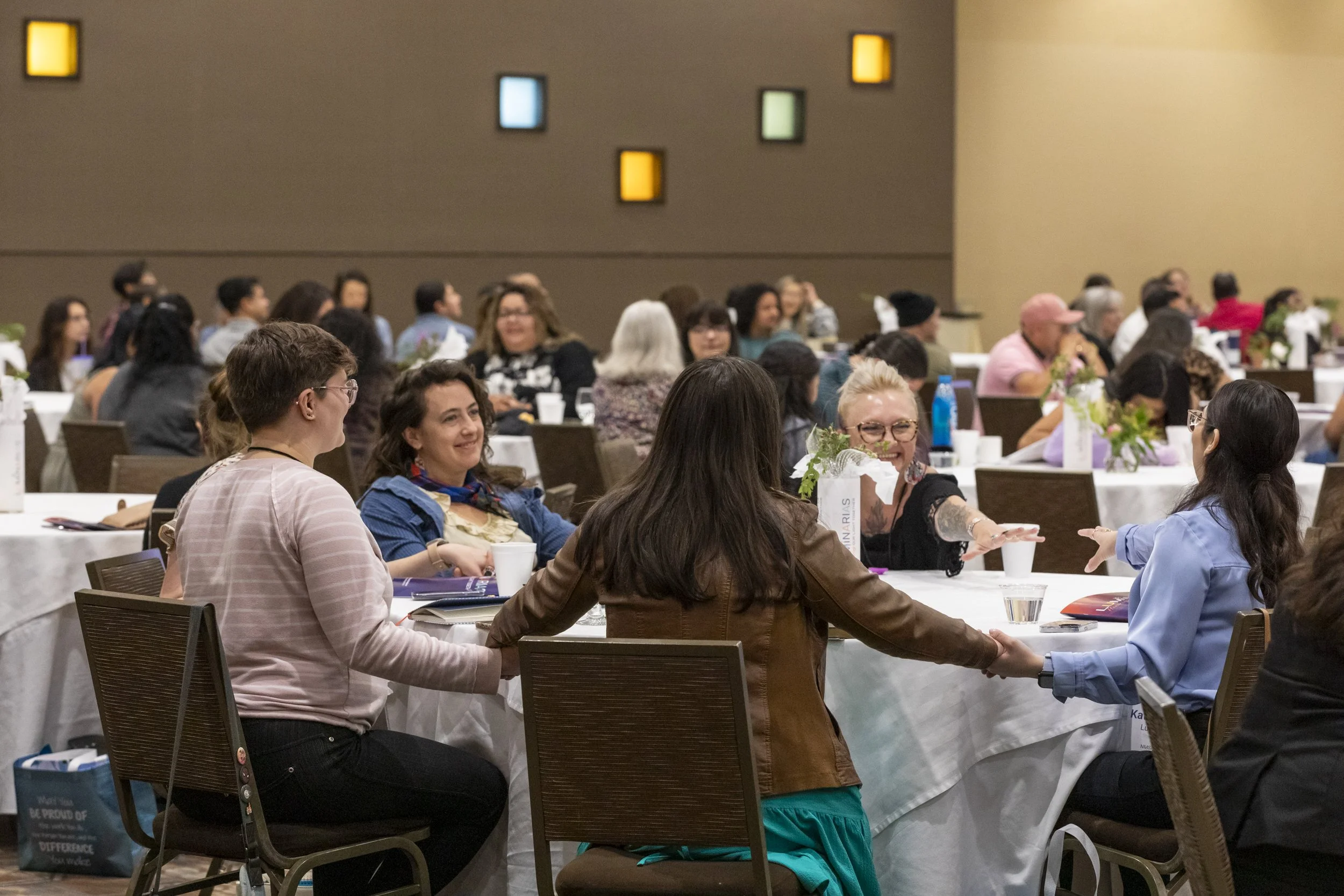 A table of people holding hands