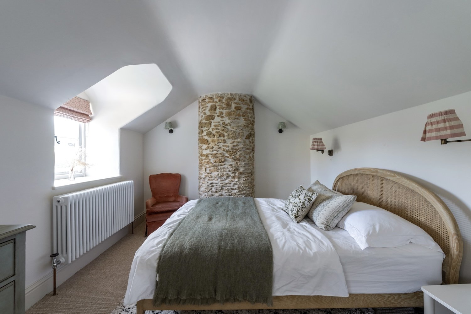 Double bedroom with curved exposed, stone, lime-pointed  chimney breast