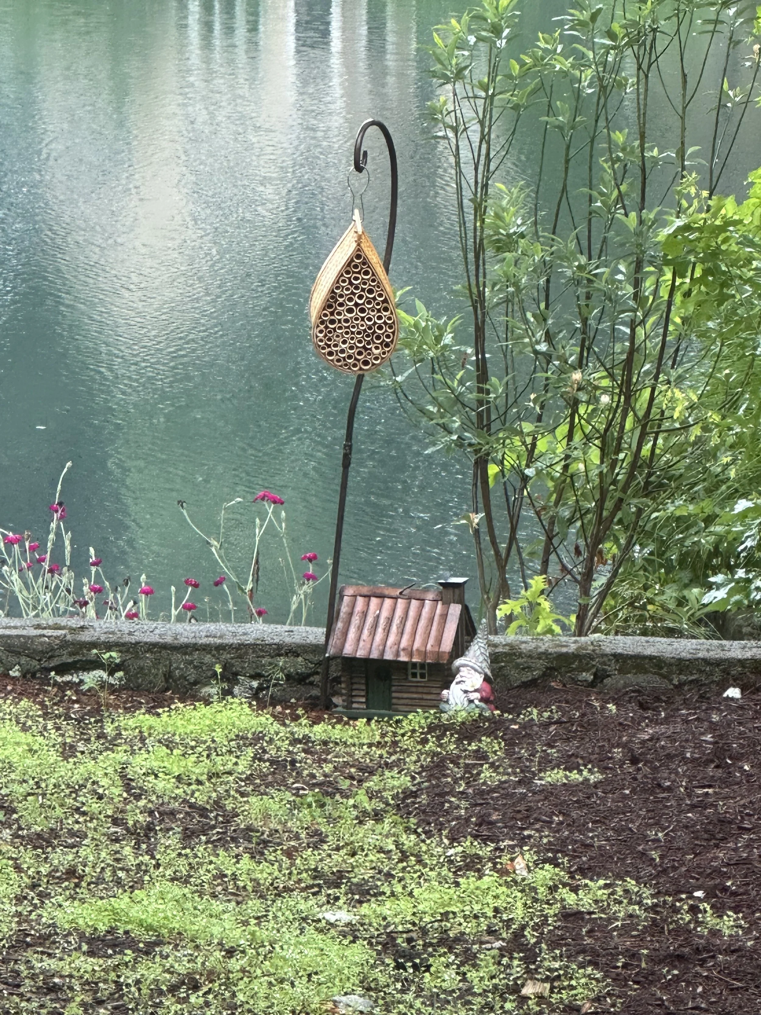 A gnome with a little cottage and bee home