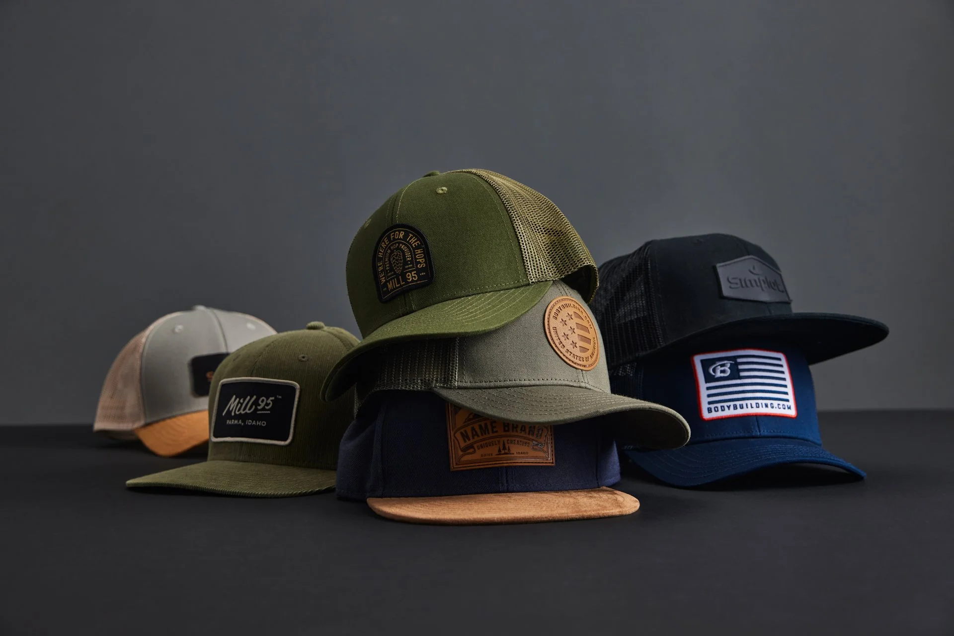 Assorted baseball caps in various colors and designs on a dark background.