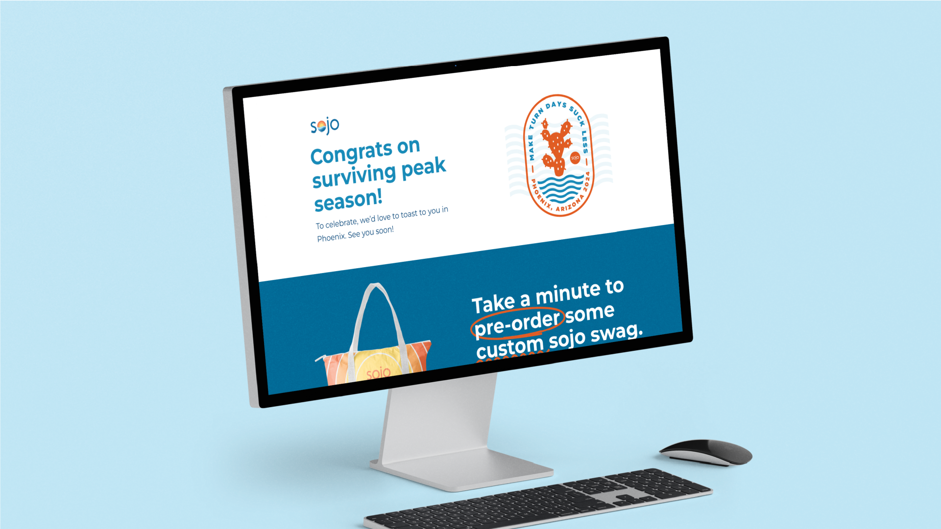 Computer monitor on desk; screen displays a congratulatory message for surviving peak season from Sojo, with a cactus emblem for Phoenix, Arizona 2024. Promotes pre-order custom Sojo swag, featuring a tote bag image.