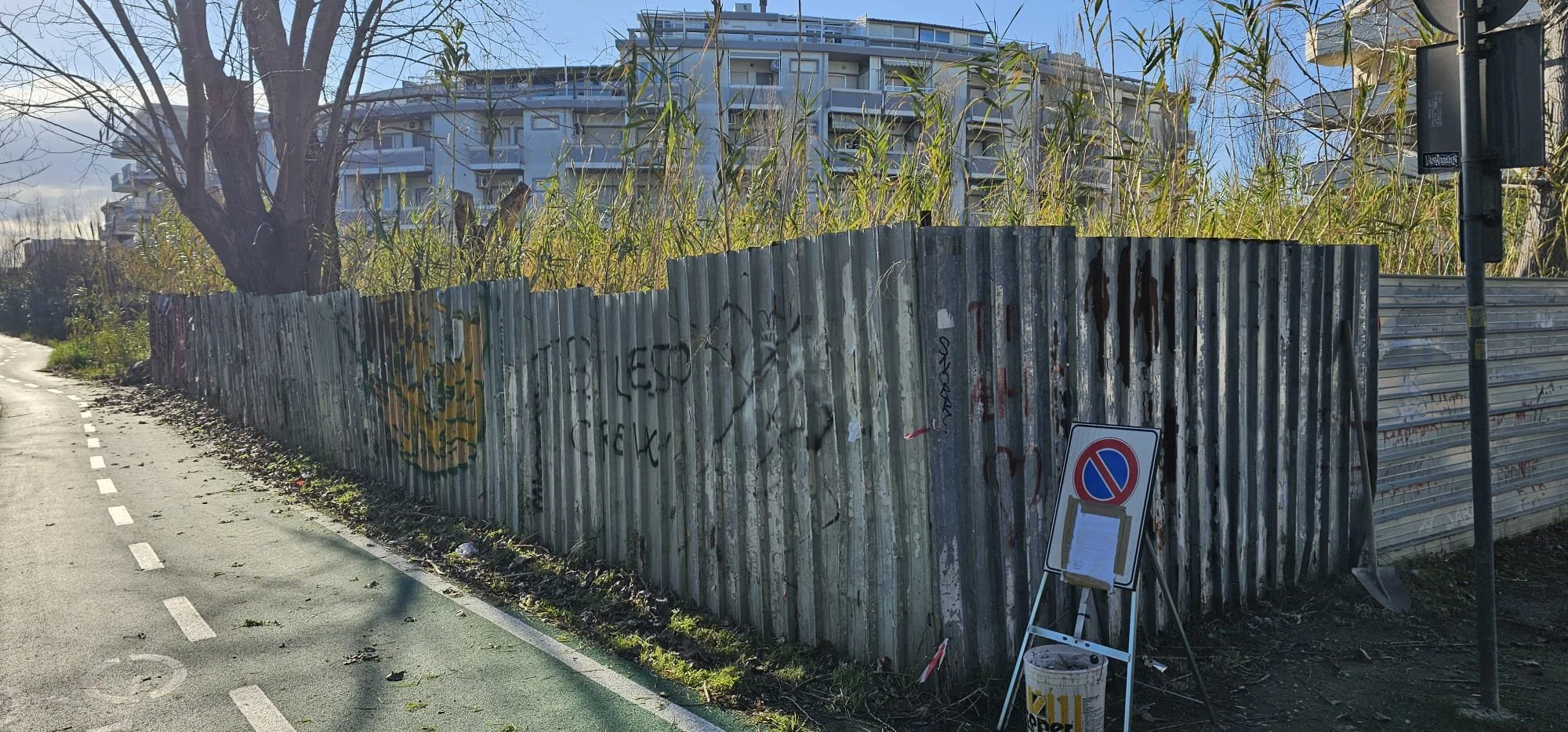 Stato iniziale con vecchia recinzione in lamiera degradata e vegetazione incolta a Vasto Marina