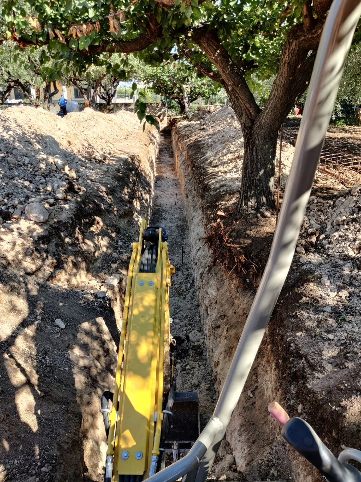 Dettaglio della fase di scavo meccanizzato per le fondazioni di un nuovo muro di recinzione a Vasto - Impiego di miniescavatore.
