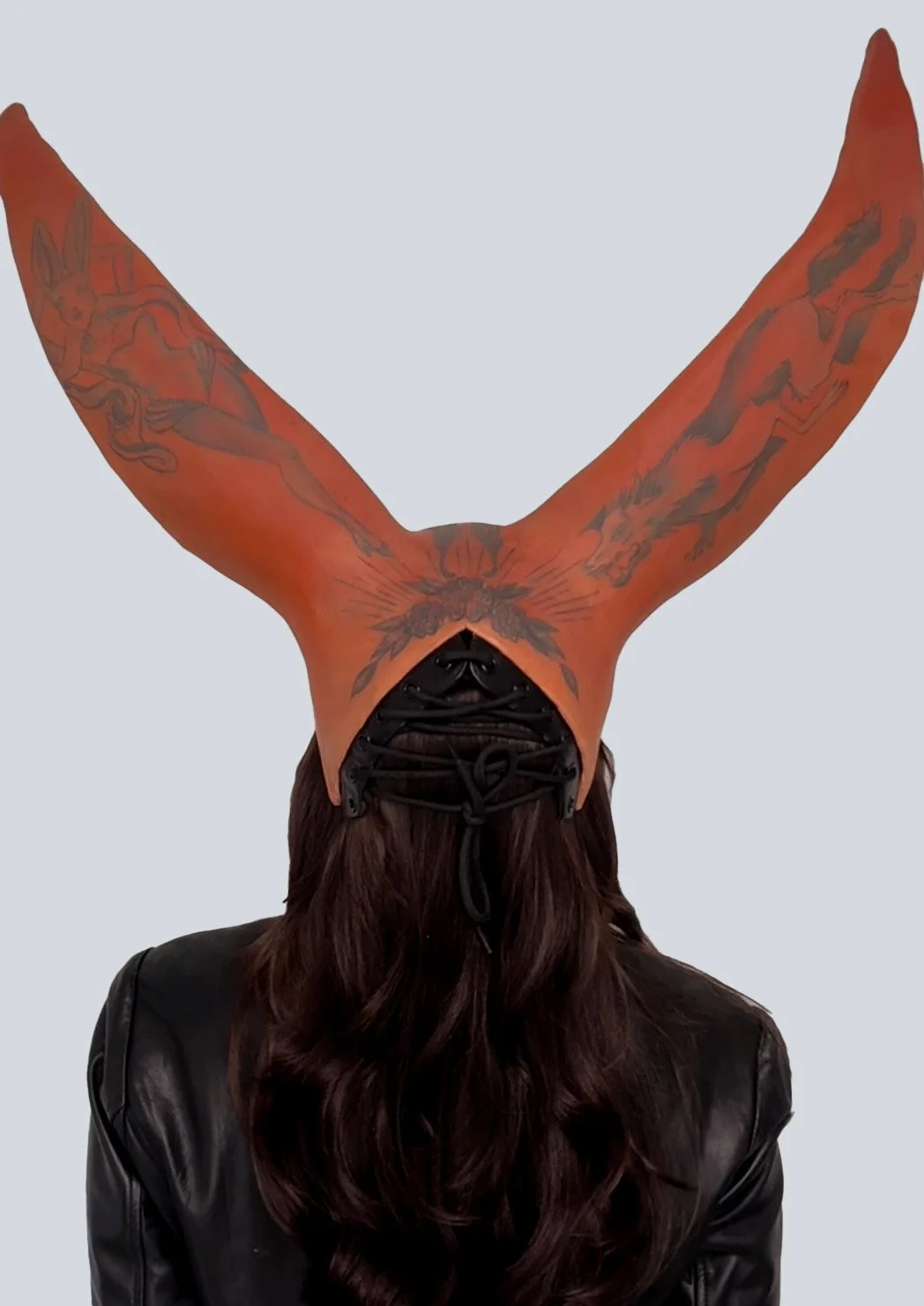 Tattooed sun bunny mask. Sculptural headpiece painted with tattoos of a rabbit and a wolf on the back of the mask by contemporary artist Giana Amantea. 