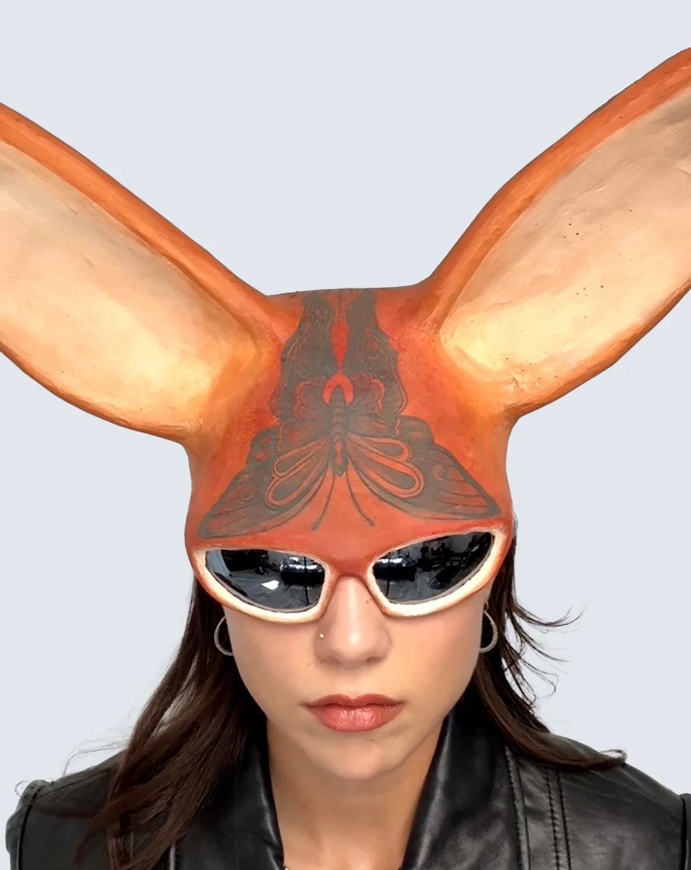 Tattooed sun bunny mask. Sculptural headpiece depicting a butterfly tattoo created from paper mache, plaster, and paint by artist Giana Amantea. 