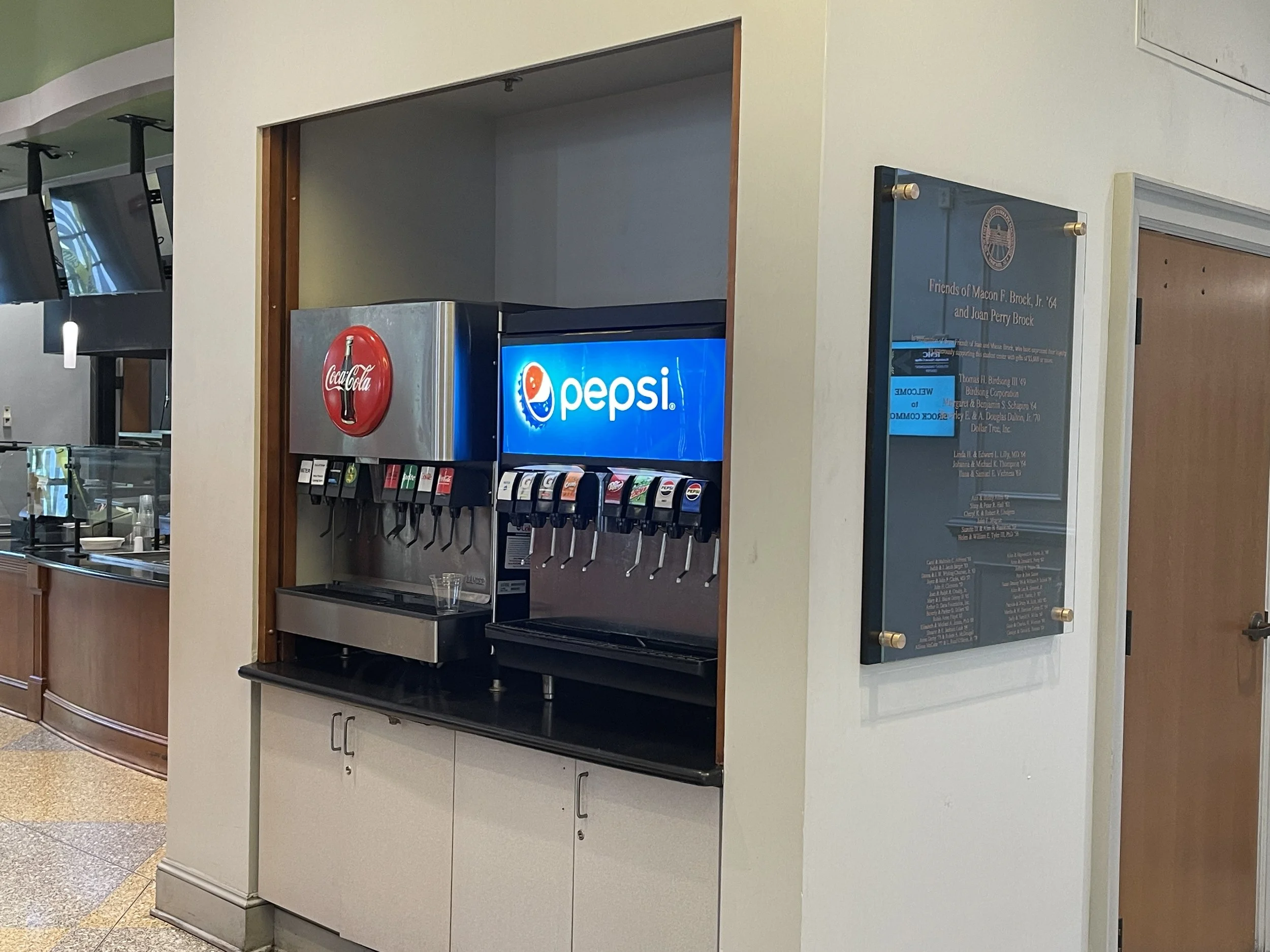 A self-serve fountain soda machine at Randolph-Macon College dispensing both Coca-Cola and Pepsi products.
