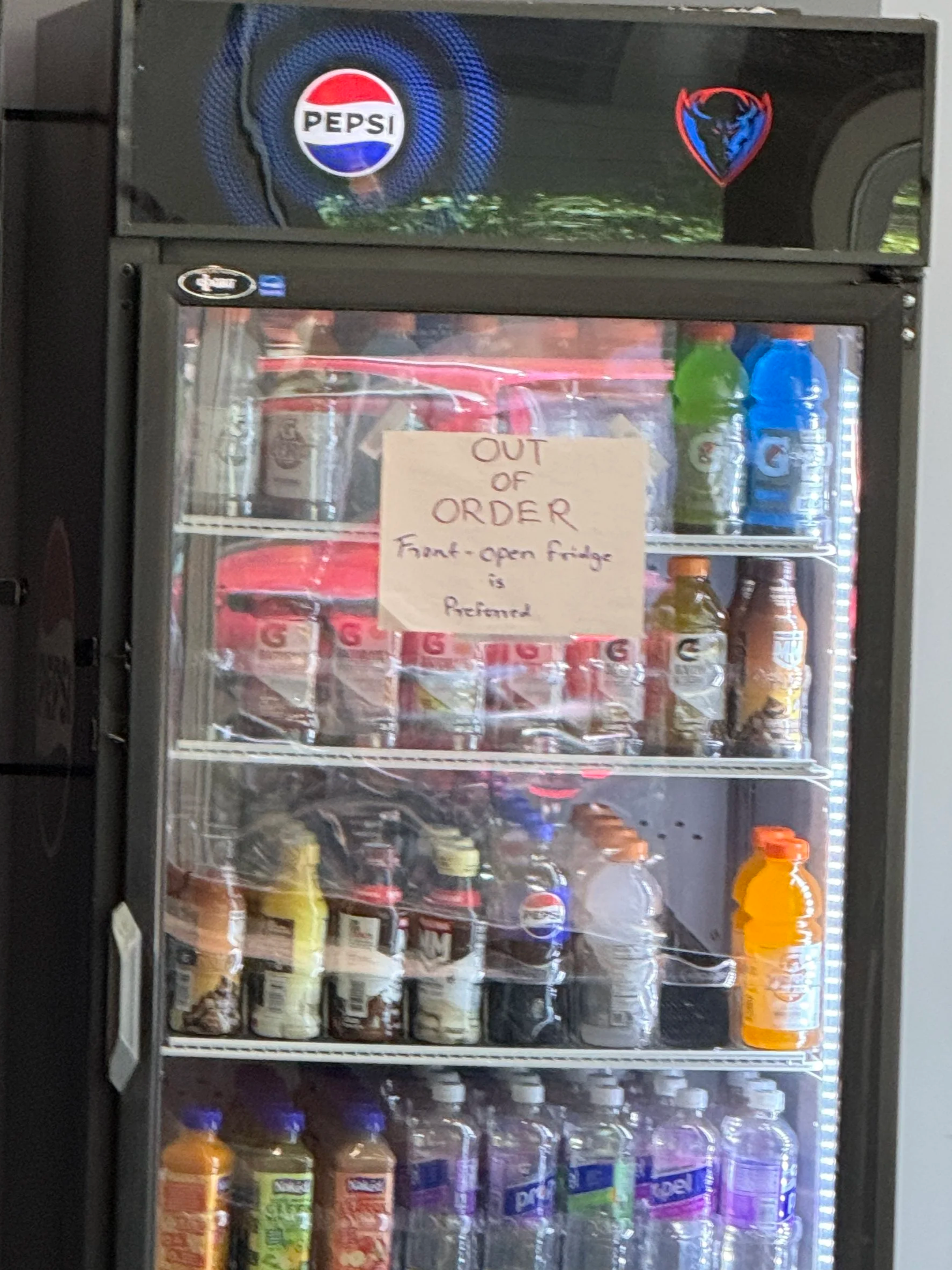 A Pepsi-branded vending cooler at DePaul University with a handwritten out-of-order sign taped to the door.