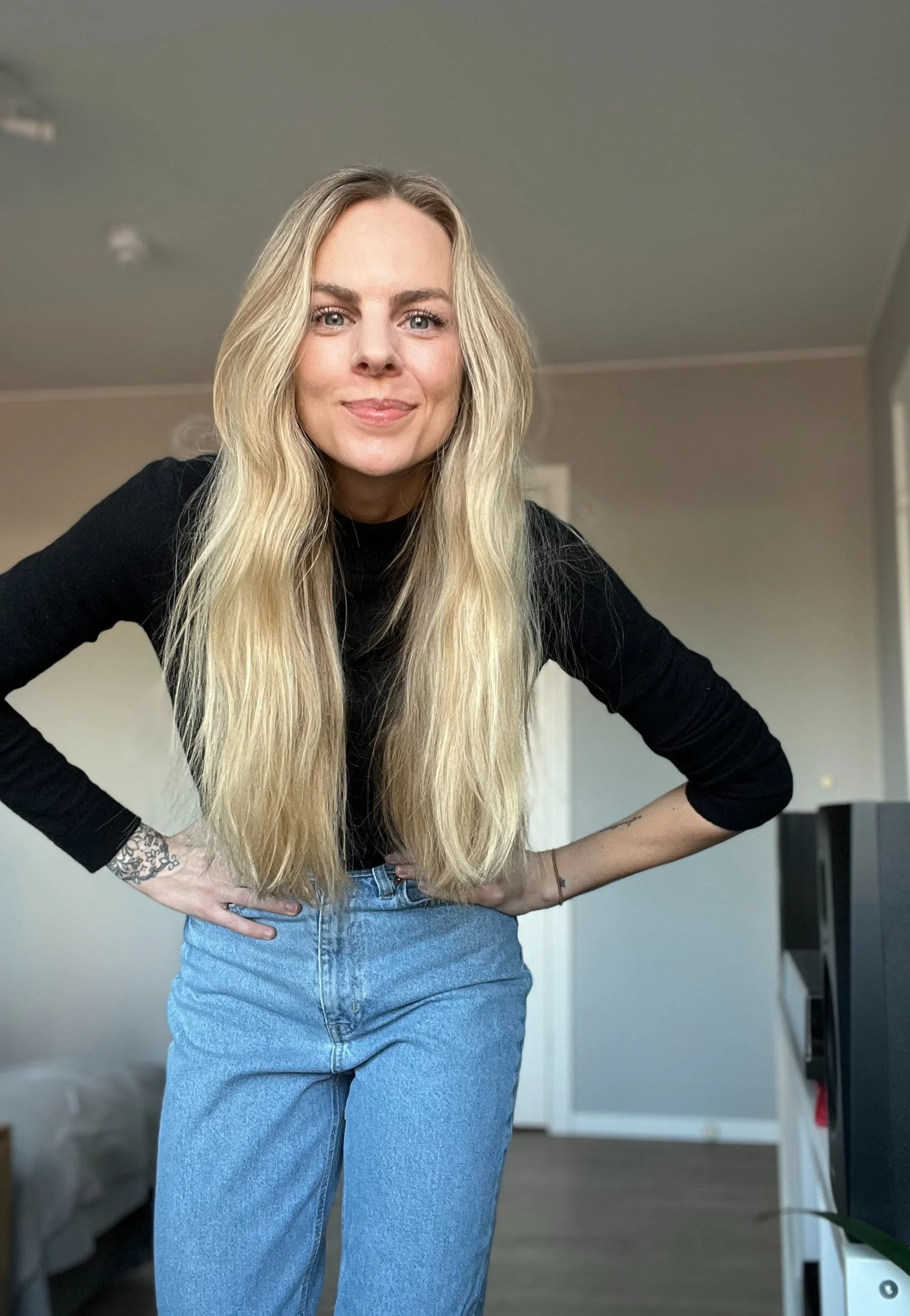 Kvinne ansatt i Fres kommunikasjon med blondt hår smiler og har armene i siden