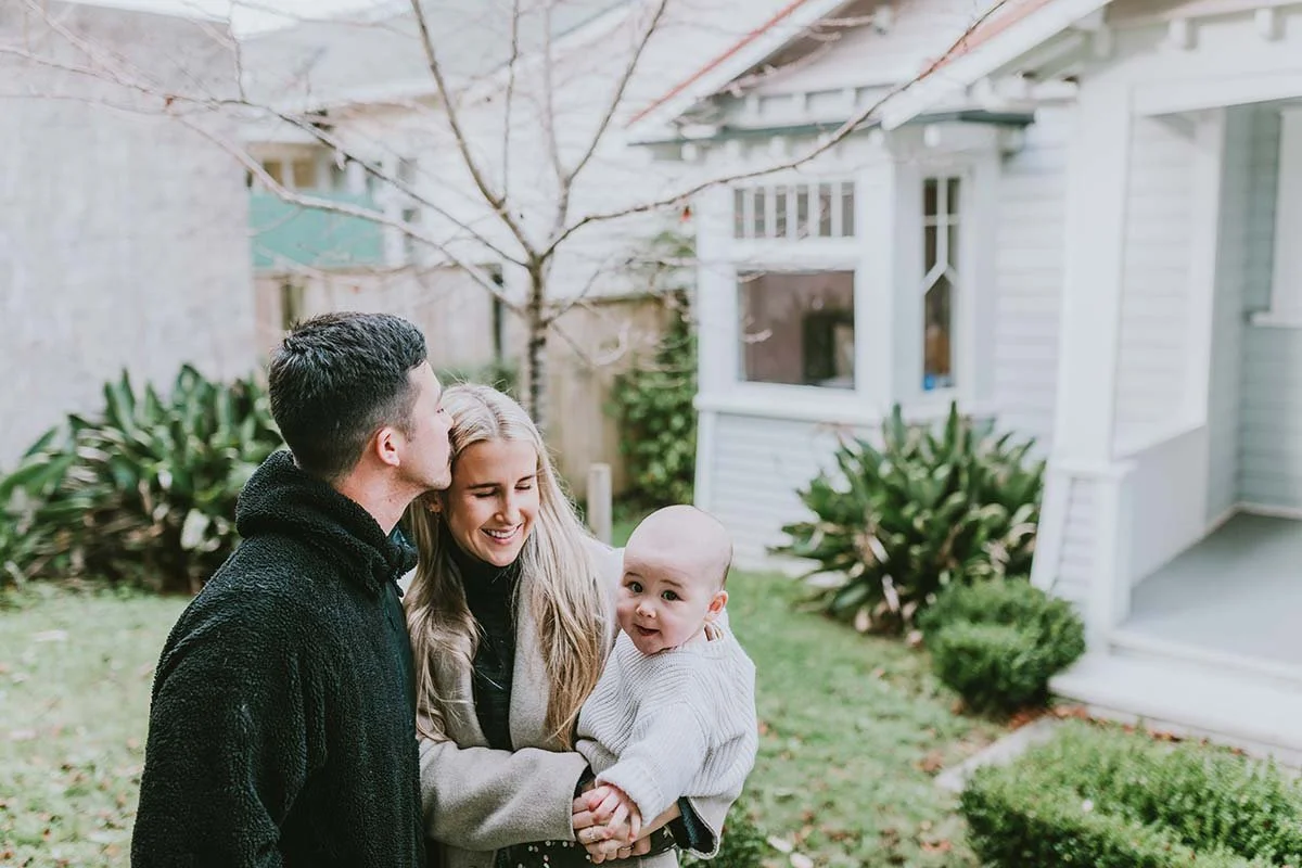Mother father and toddler in group hug at home