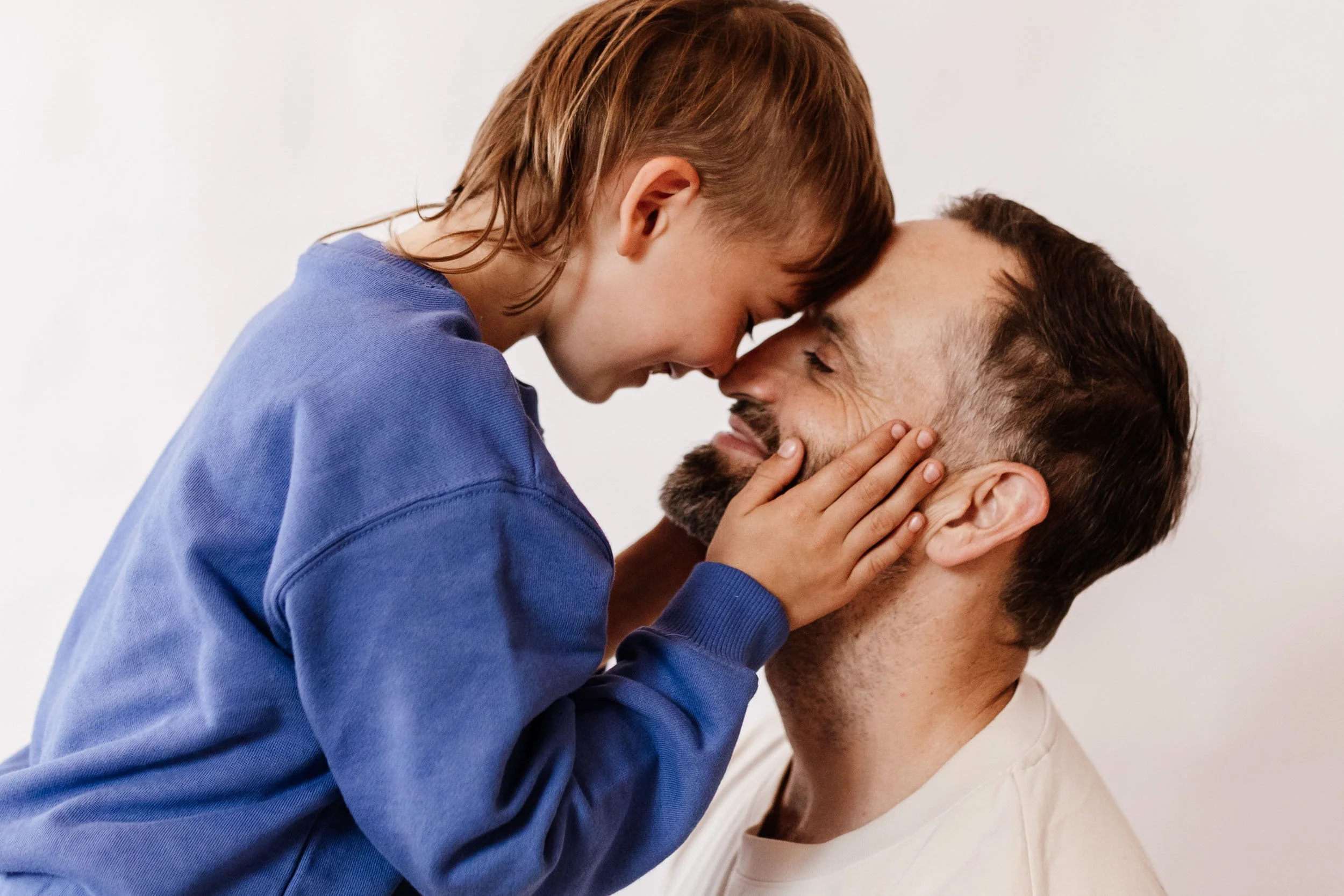 Father and son hongi smiling at each other
