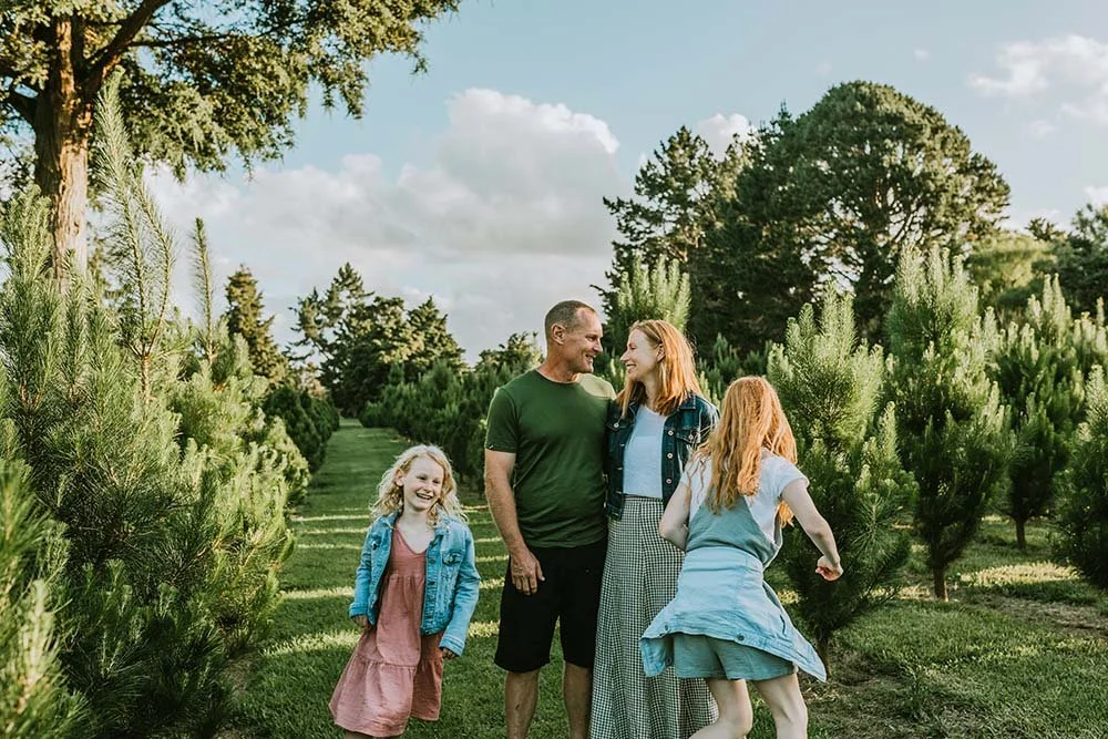 Mother, father, and two teenage girls having fun in nature