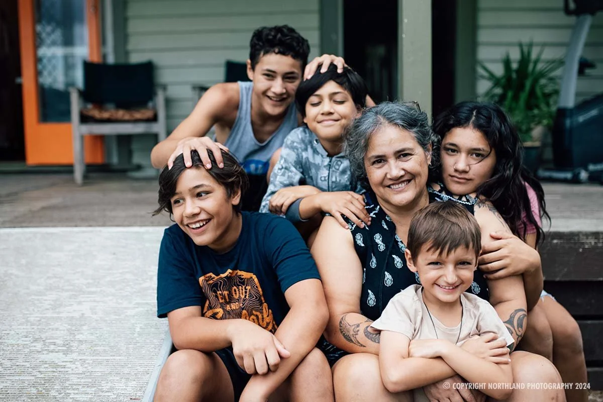 Extended whānau photograph smiling in front of camera. All of our images are protected by copyright and available to purchase on True Stock NZ. 