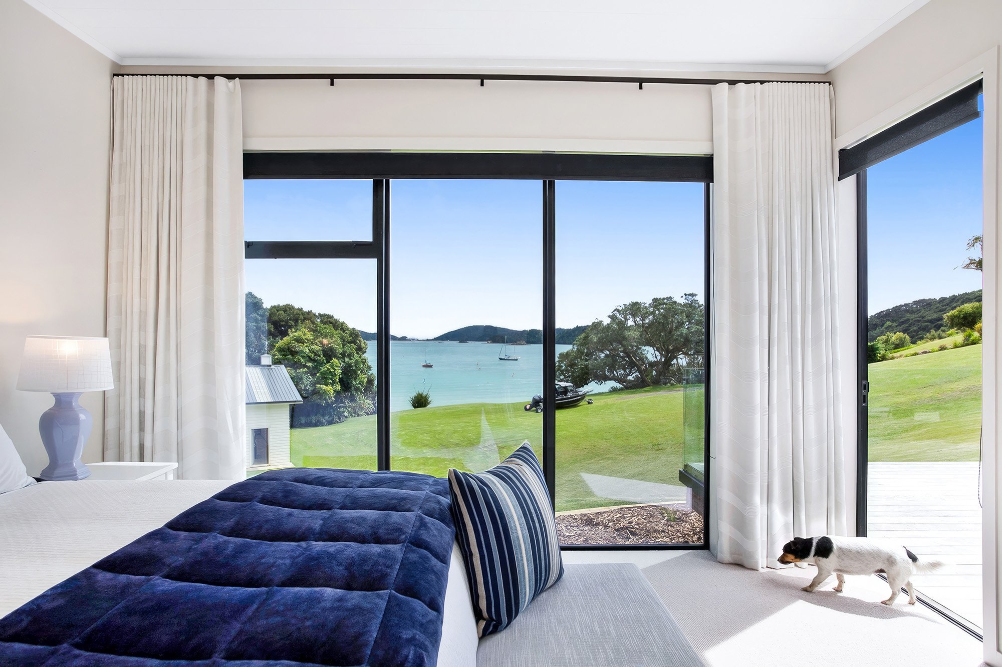 Bedroom overlooking grass and ocean in Bay of Islands