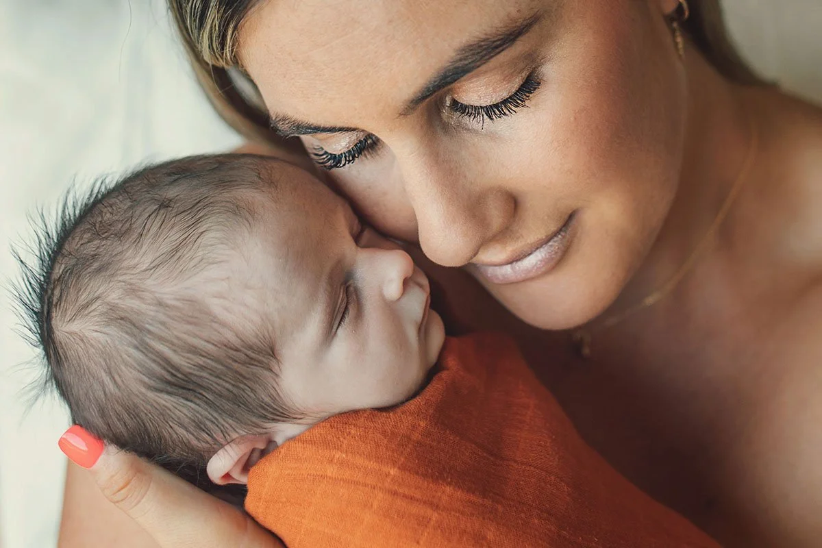 Mother newborn photoshoot rocking baby 