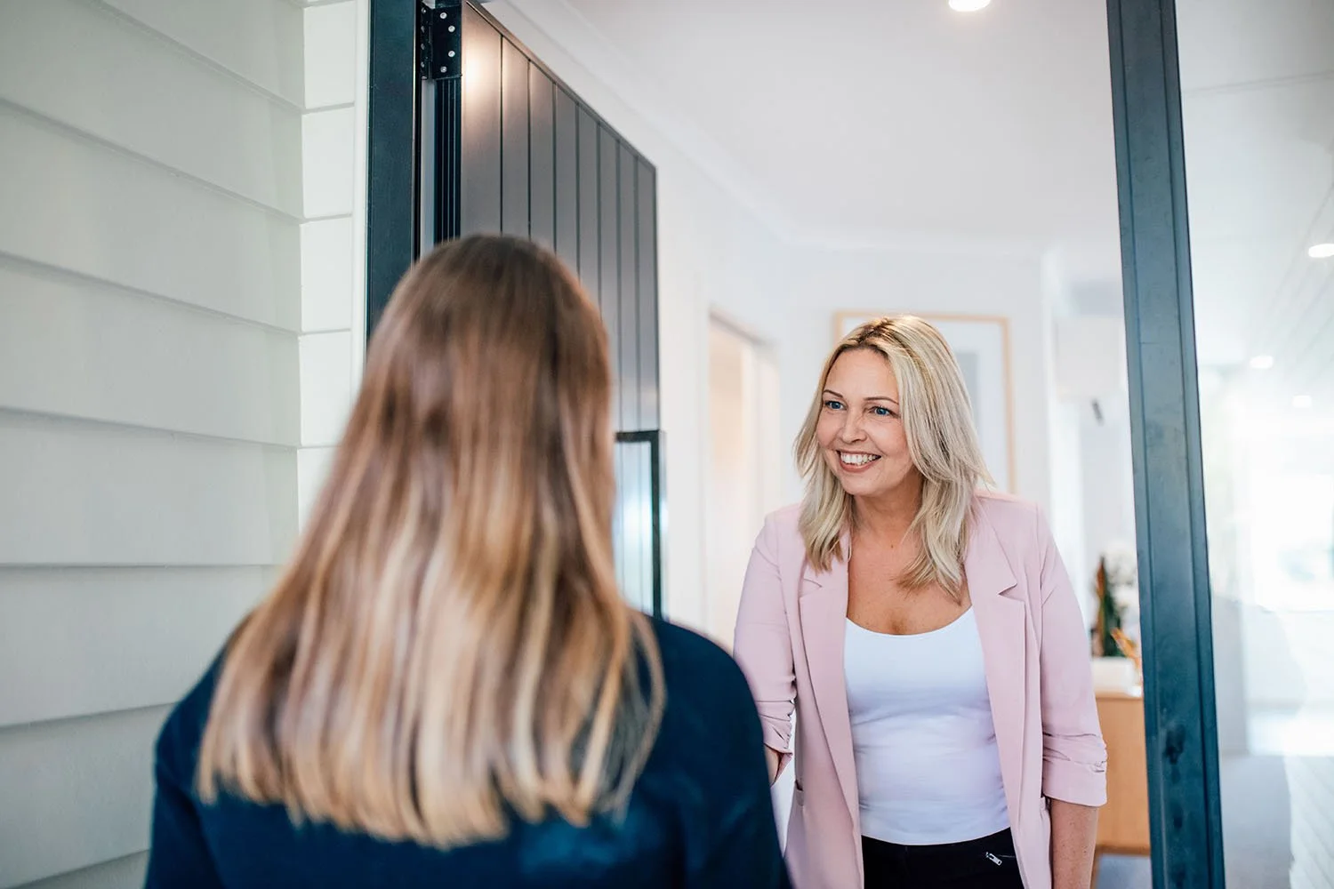 Business branding image of owner meeting client at door