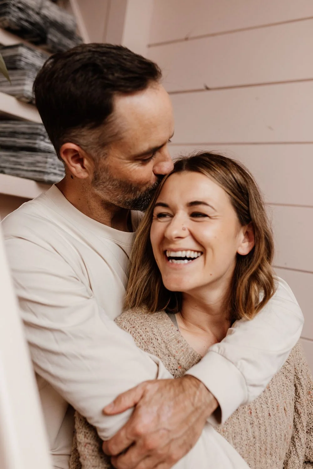 Couple photoshoot embracing on stairs at photography studio