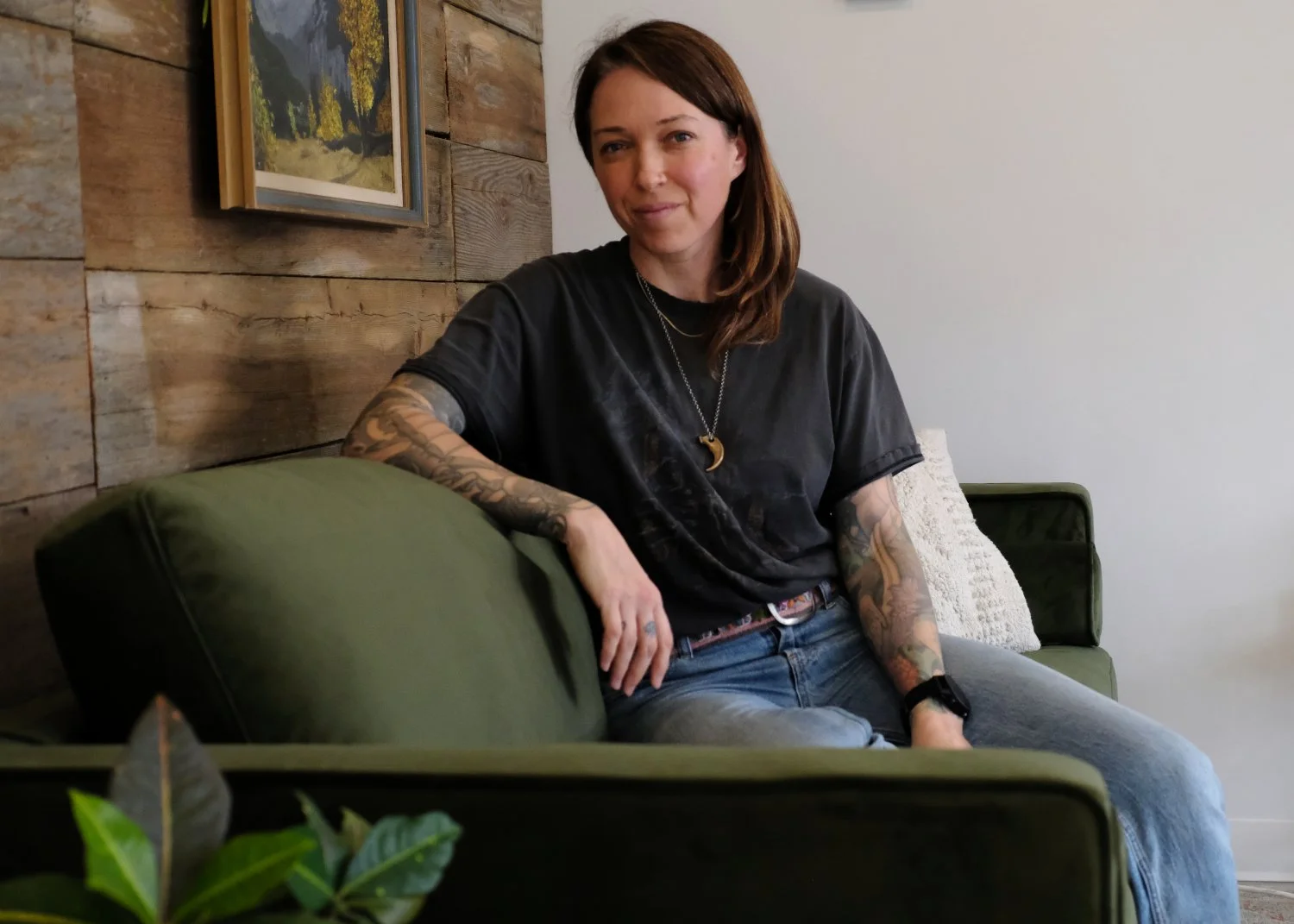 Sarah Tesla sitting on a couch looking at the camera