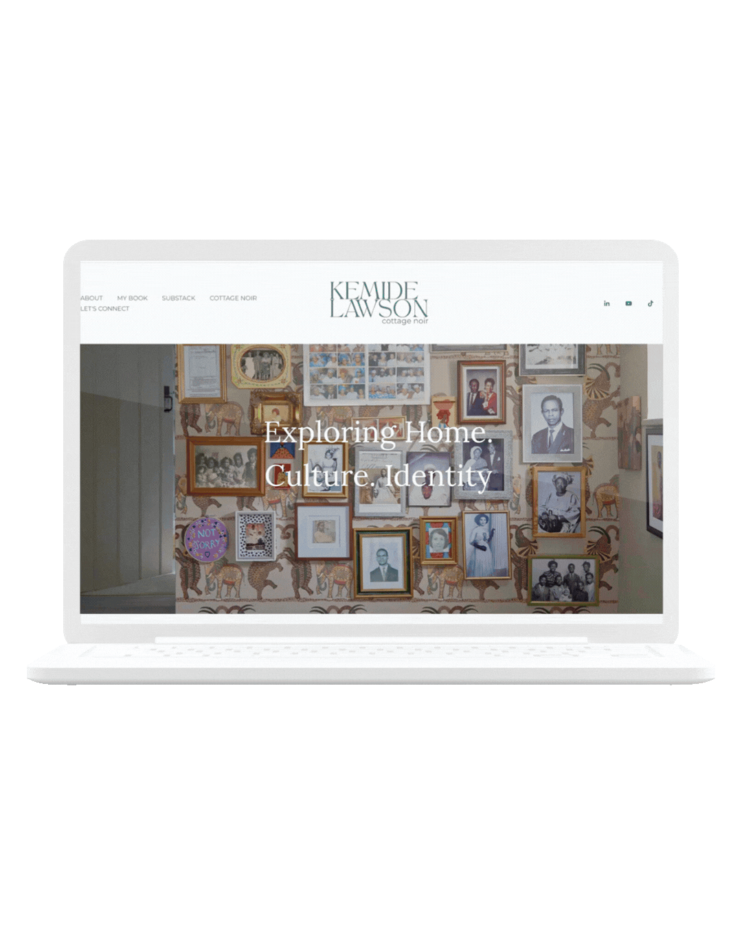 Laptop displaying a website with a wall of framed photographs and artwork, and overlaid text reading, "Exploring Home. Culture, Identity."