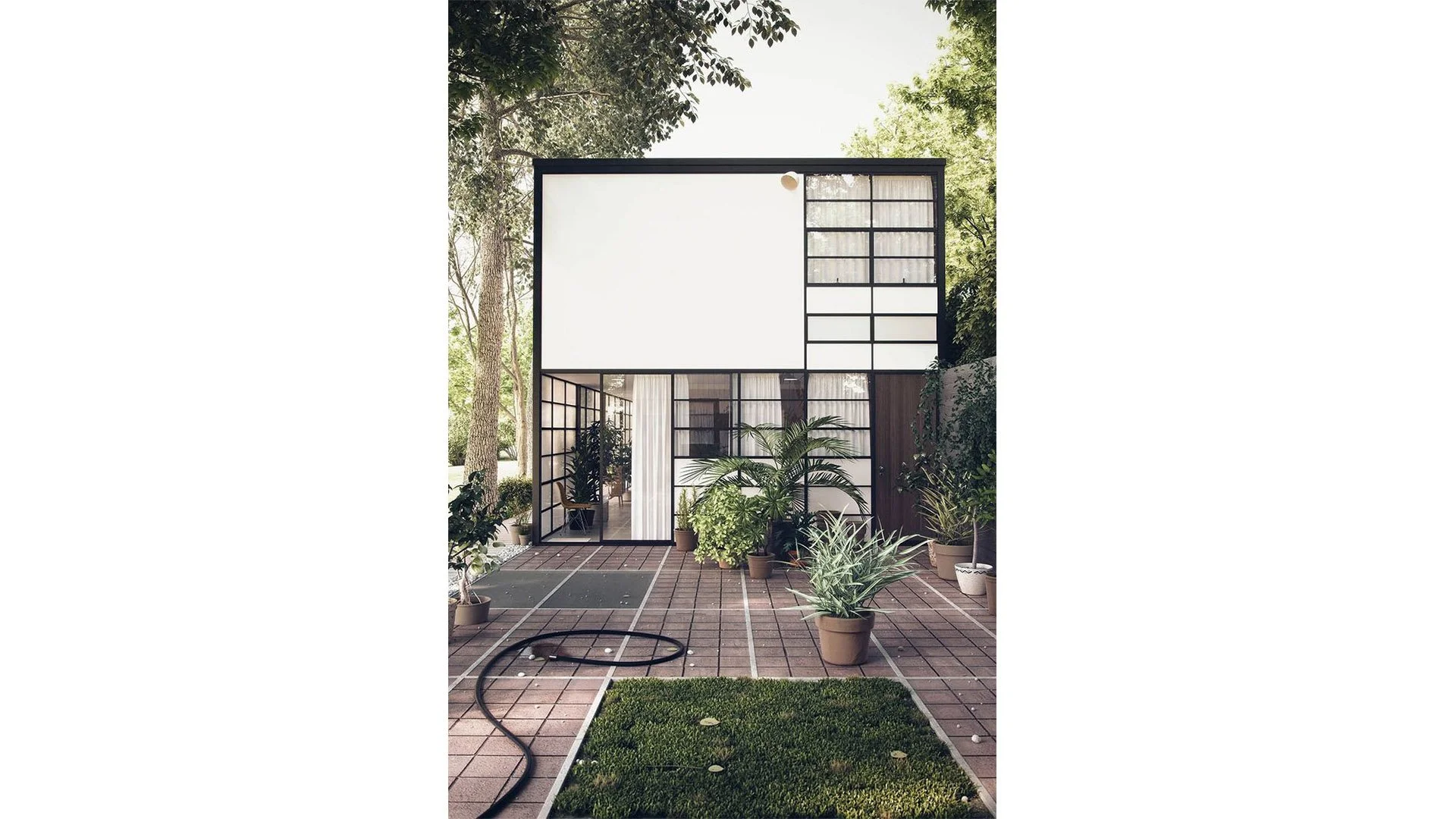 Modern house with glass doors and windows, surrounded by potted plants, on a patio with brick flooring, trees in the background.