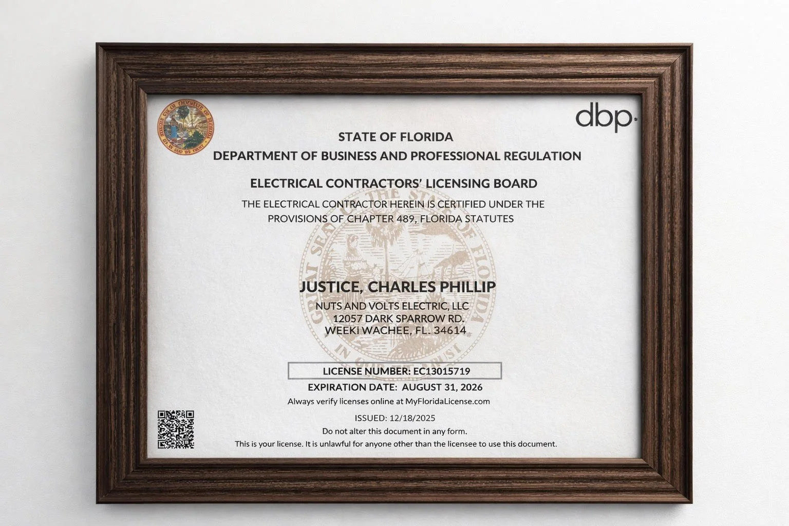 Florida electrical contractor's license framed on wall, showing license details, license number EC13015719, expiration date August 31, 2026, issued to Charles Phillip Justice of Nuts and Volts Electric, LLC.