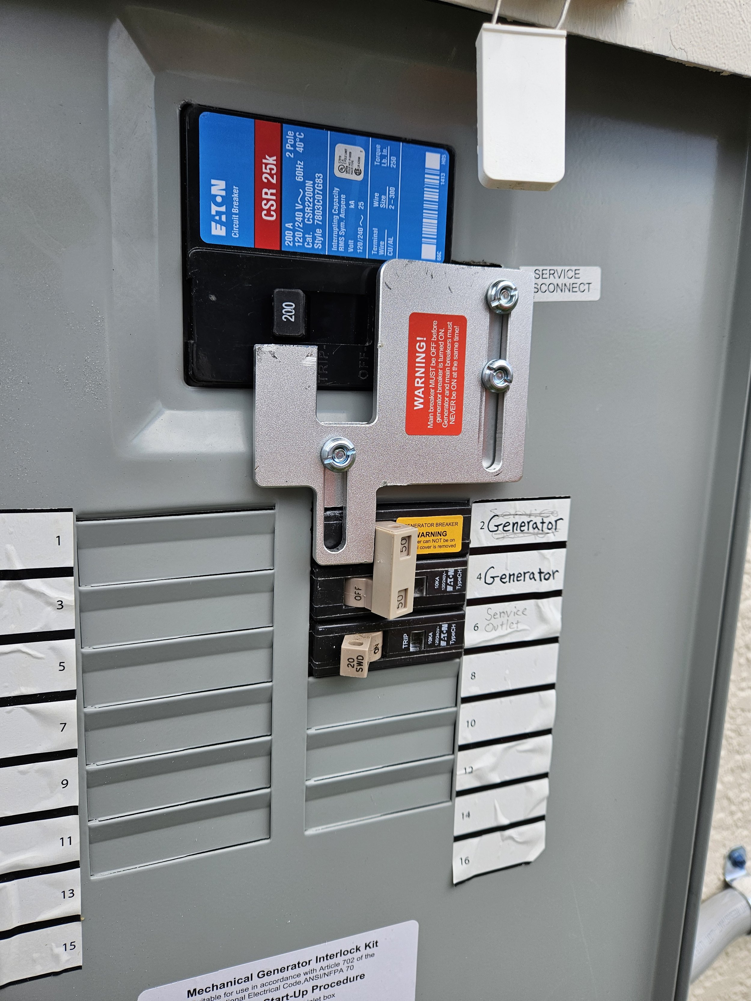 Electrical panel with circuit breakers, labels, and warning signs.