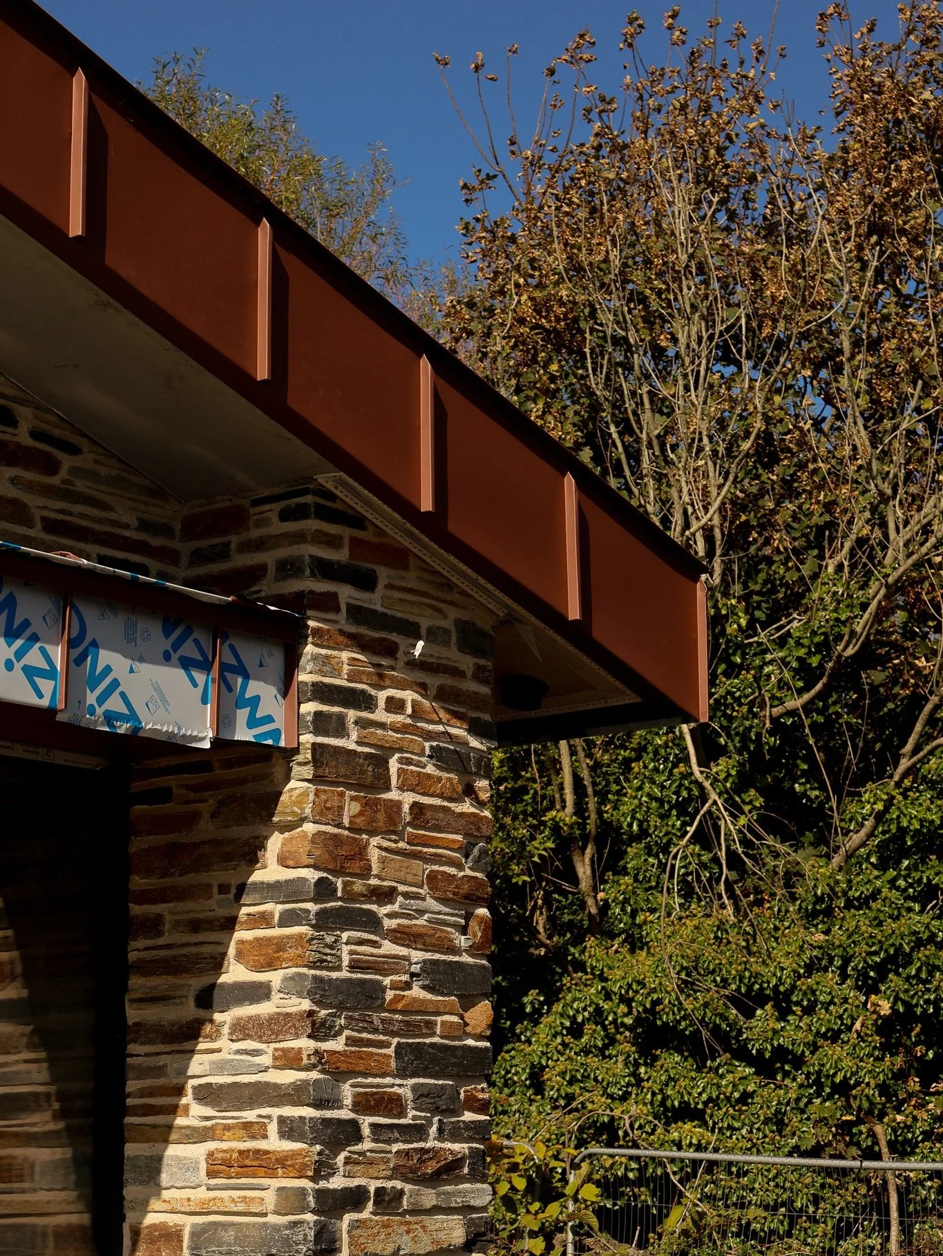 The building features red zinc fascia carefully installed around its perimeter, a complex task that required following the curvature of the structure while ensuring precise alignment and consistent positioning from every viewpoint.

The combination o