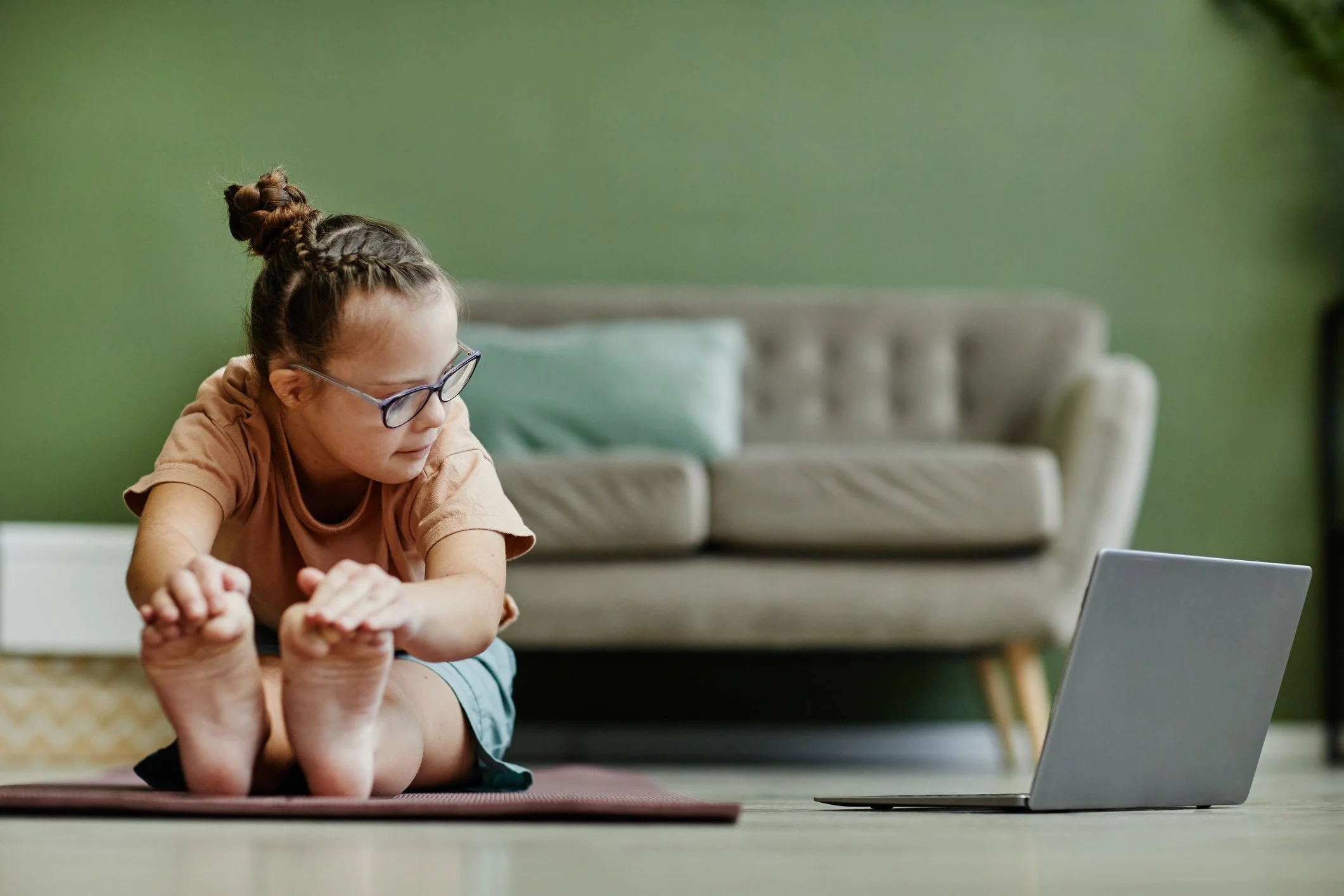 A young girl completing movement therapy remotely.