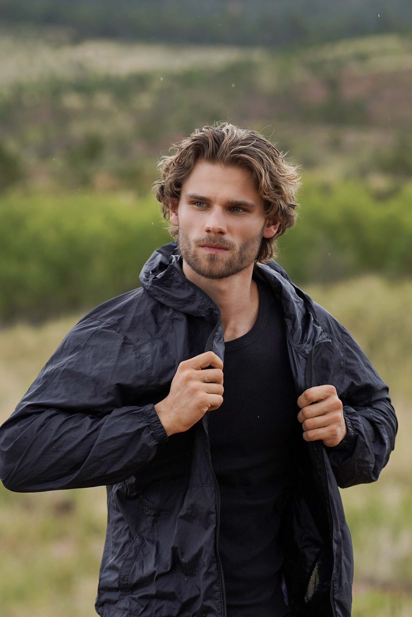 Stepan Salomatin in a black windbreaker with mountains behind him