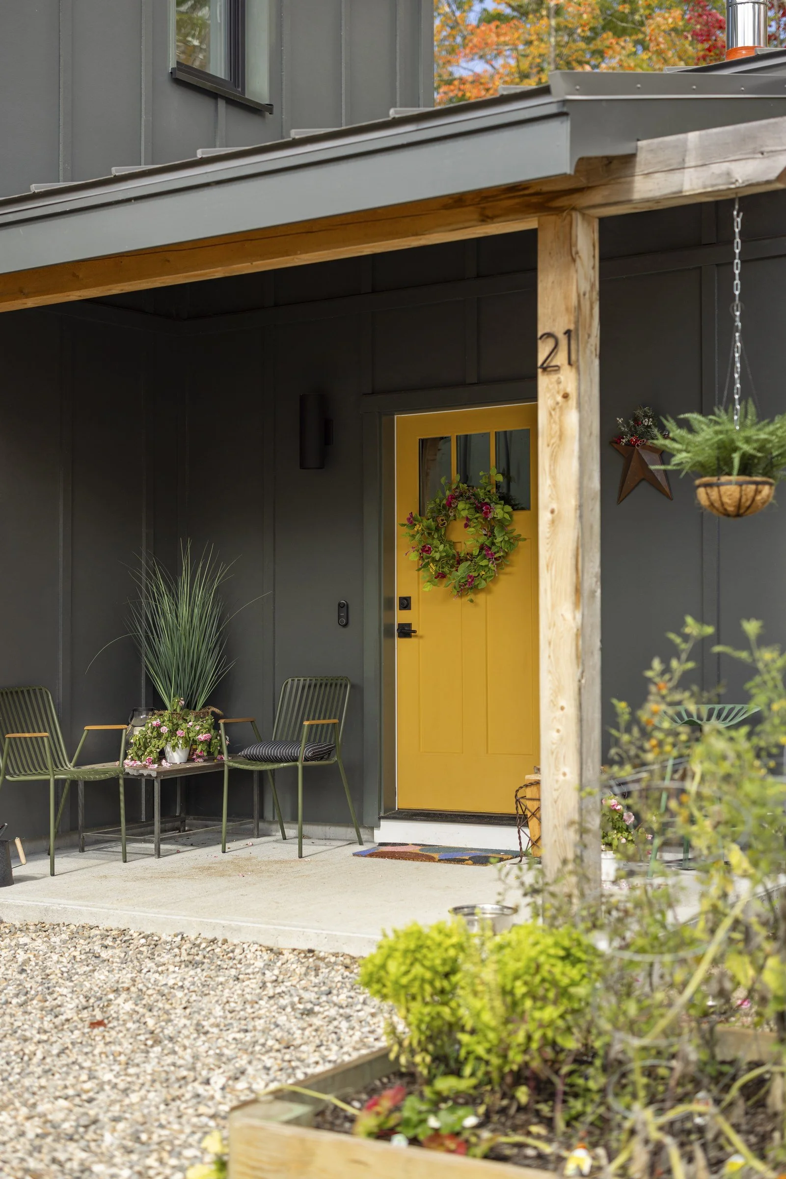 Covered entry porch with timber posts and a yellow front door.