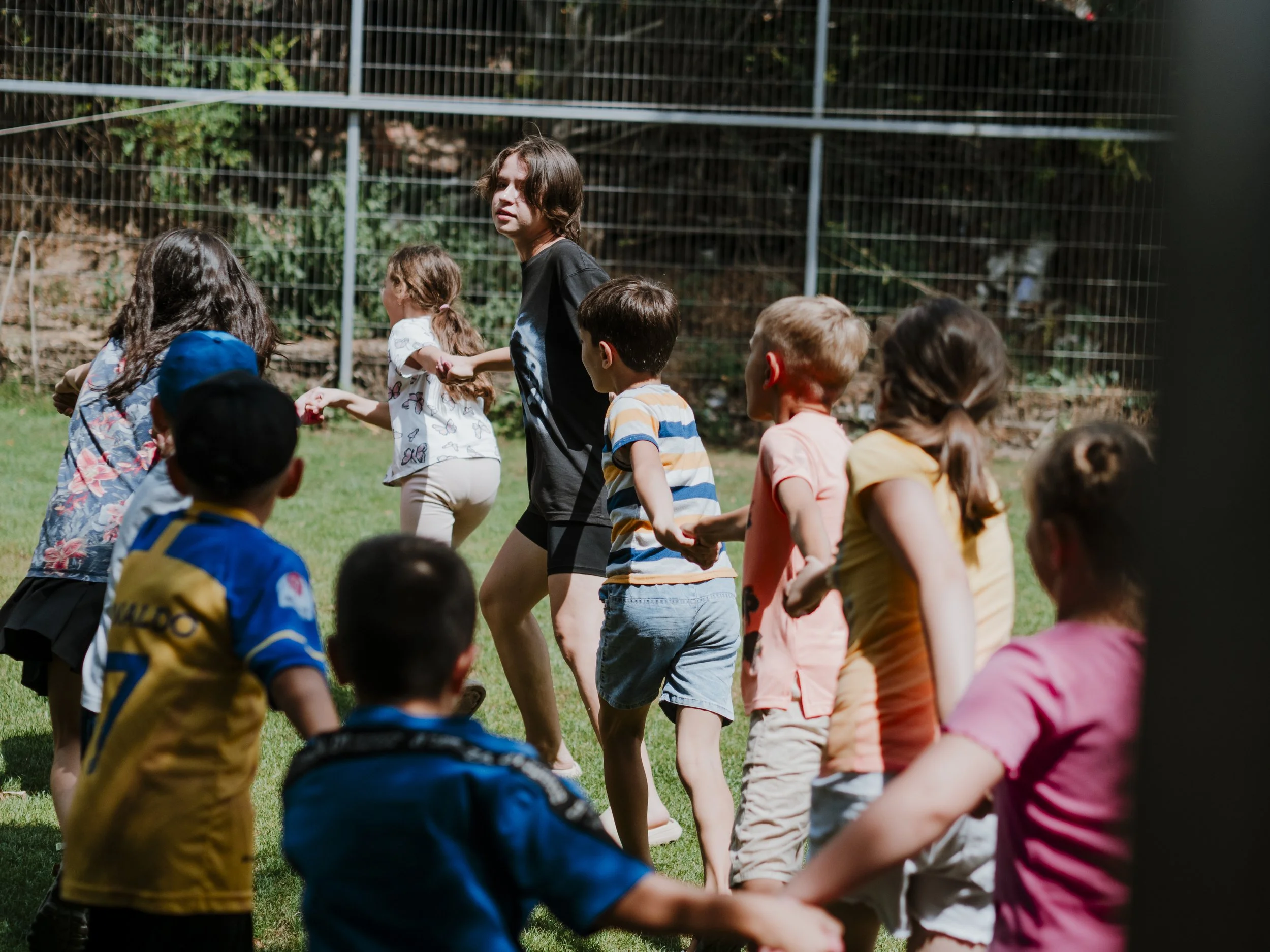 Group of kids holding hands with the leader at a kids camp