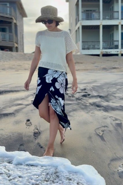 Chic summer knit top with a breezy lace yoke and delicate lace trim, perfect for effortless beach fashion. This lightweight, short-sleeved sweater drapes beautifully for a relaxed yet elegant look.