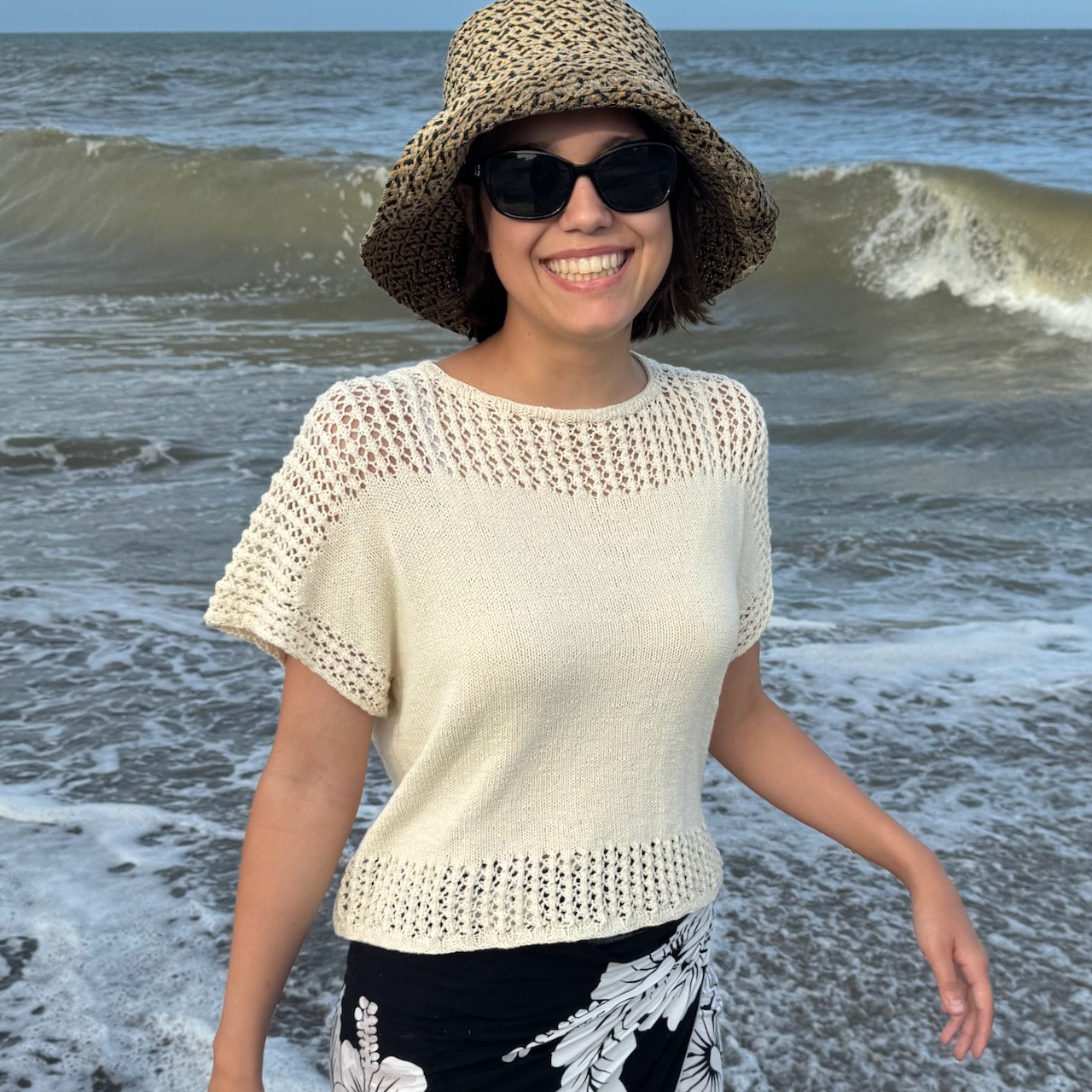 Elegant summer knit top featuring a breezy lace yoke and delicate lace trim on the sleeves and hem. This lightweight, short-sleeved sweater is perfect for warm weather and effortless beachside style.
