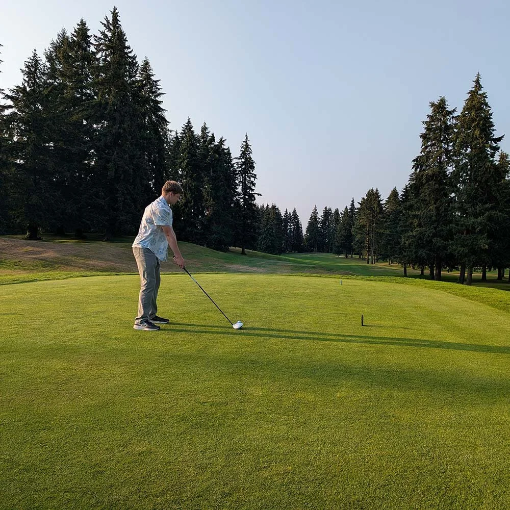 Young man stands at the 10th tee box of Fircrest golf course ready to hit his drive