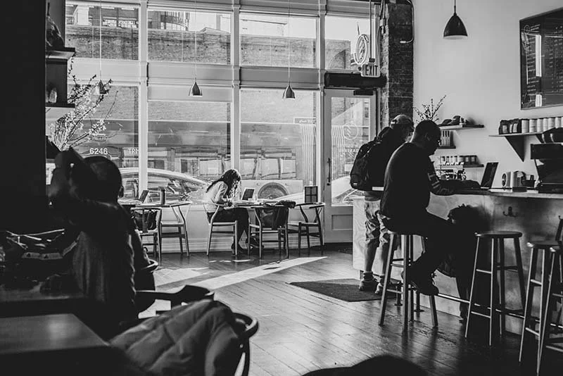 Photo of people working at a coffee shop. Black and white photo.